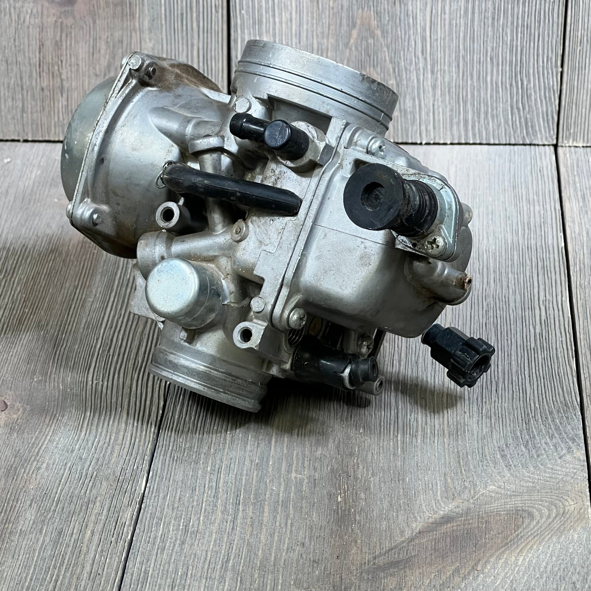 Carbhub TRX300 carburetor for Honda 300 Fourtrax 1988-2000, detailed view on wooden background.