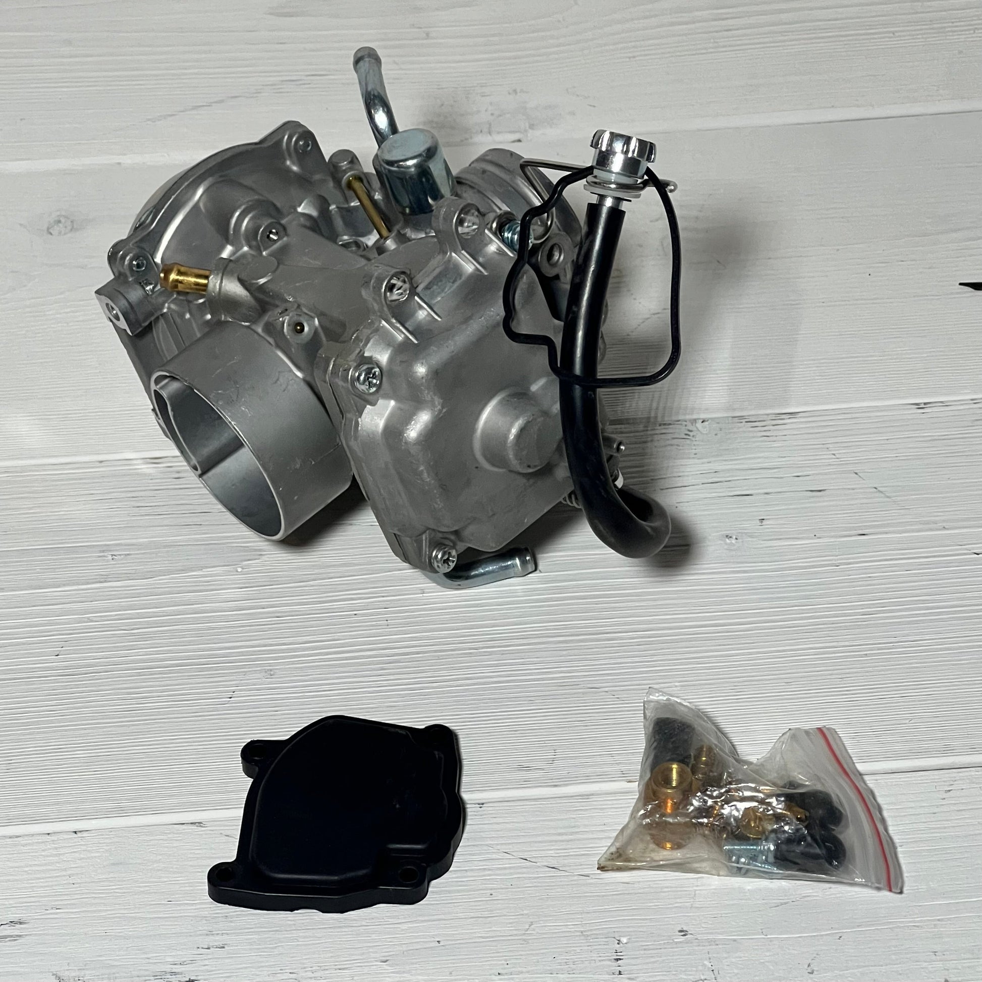 Carburetor assembly for Suzuki LT-F250 Quadrunner 250 2X4, showing main unit and additional parts on a white surface.