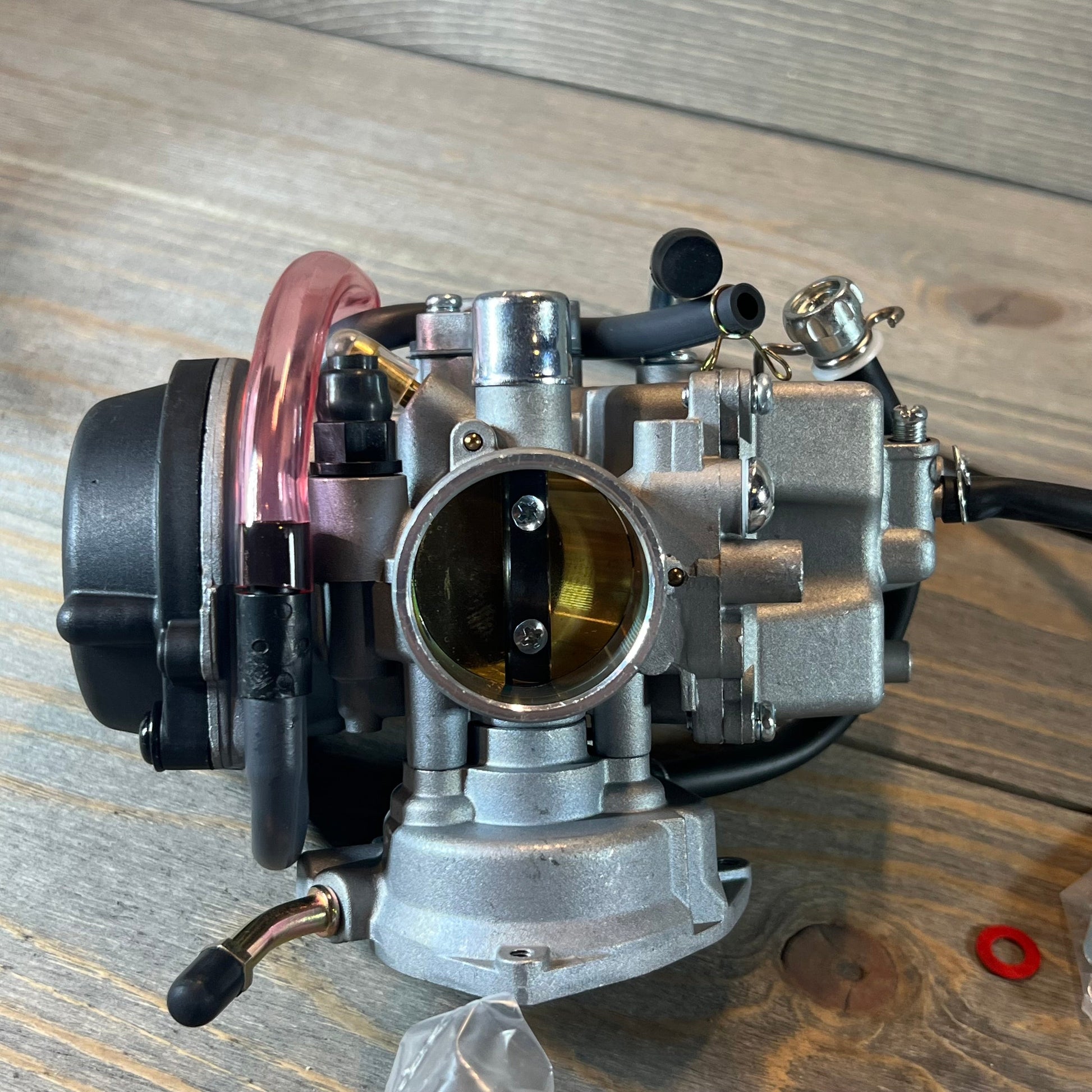 Carburetor replacement for Suzuki LTZ400 Quad, showcasing fuel valve petcock and detailed metal components.
