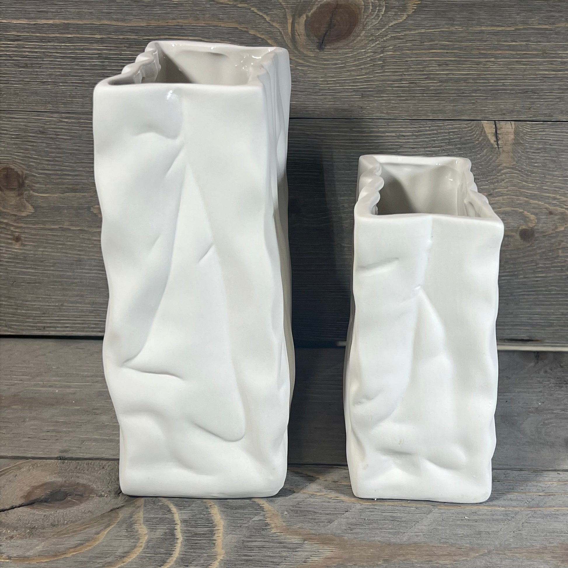 Ceramic vase set with crinkle paper bag design in crème and coconut café finish on rustic wood background.