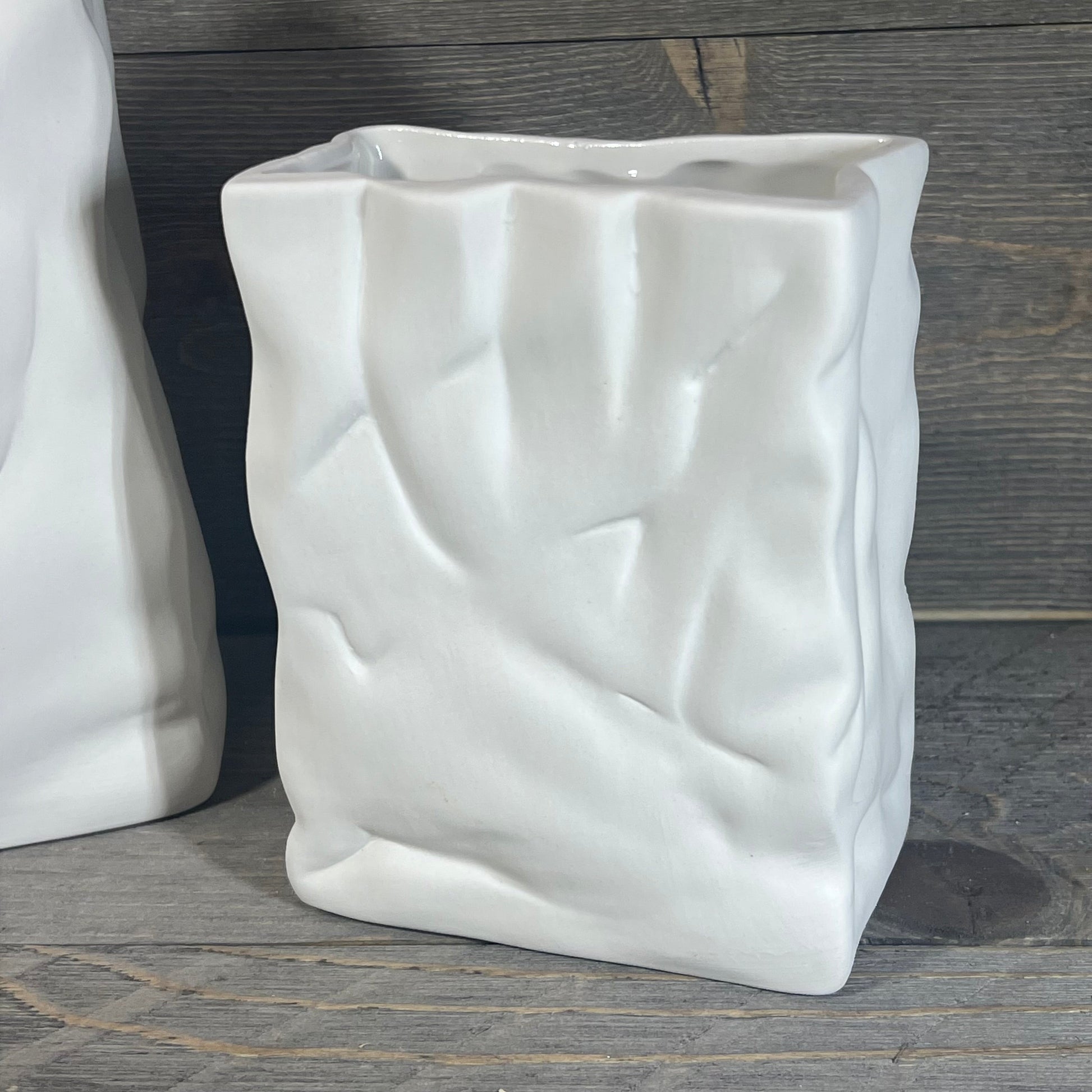 Ceramic vase with crinkle paper bag design in a smooth crème finish, perfect for modern home decor.