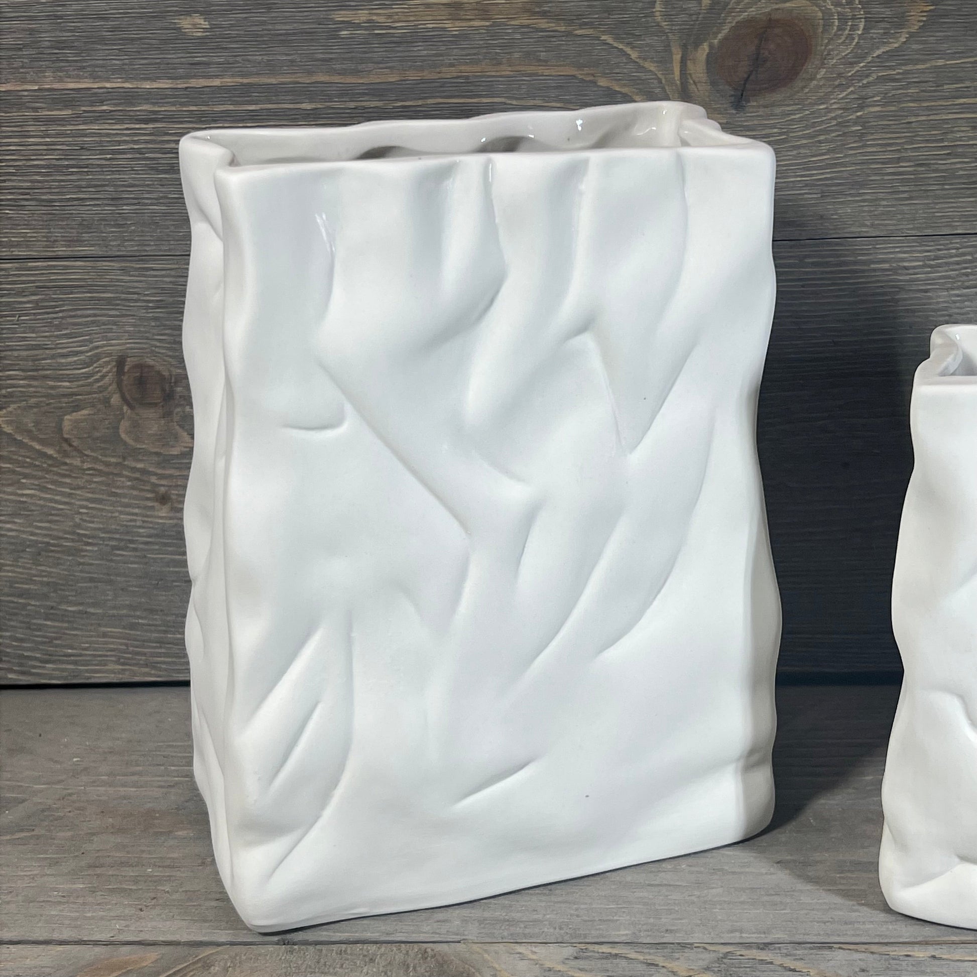 Ceramic vase with crinkle paper bag texture in crème, featuring a unique coconut café finish against a wooden backdrop.