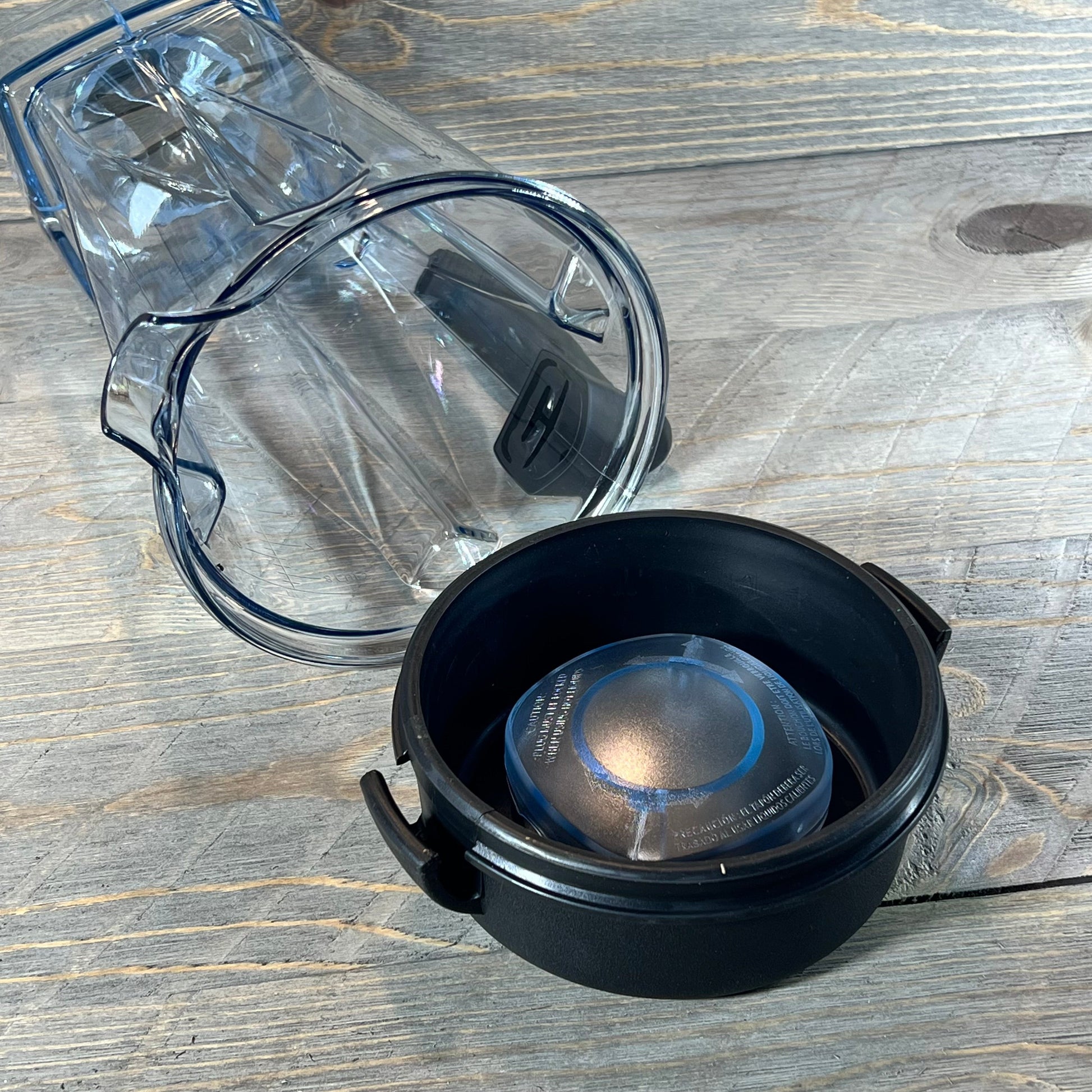 Clear 64oz blender pitcher replacement for Vitamix, shown with black lid and tamper on wooden surface.