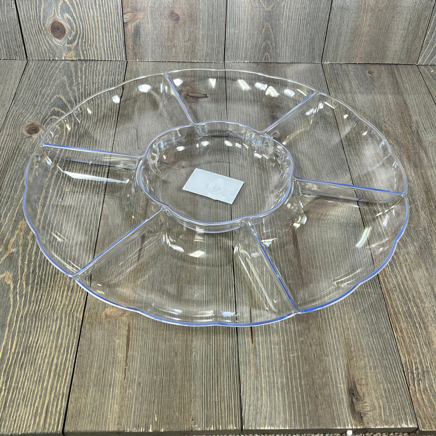Clear round serving tray with seven sections, ideal for parties. Durable hard plastic, perfect for elegant food presentation.