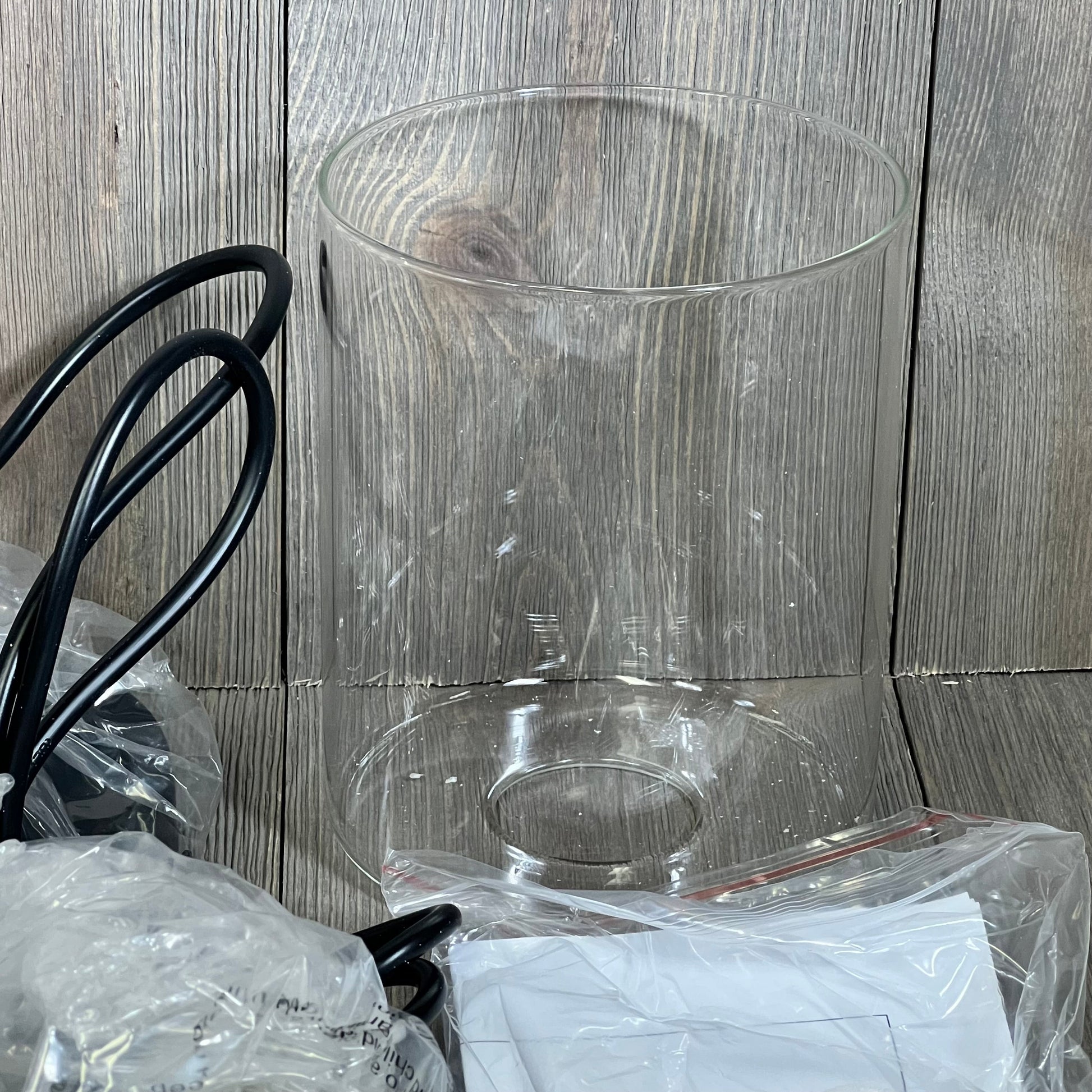 Modern farmhouse pendant light with clear glass shade and adjustable black cord, perfect for industrial decor.