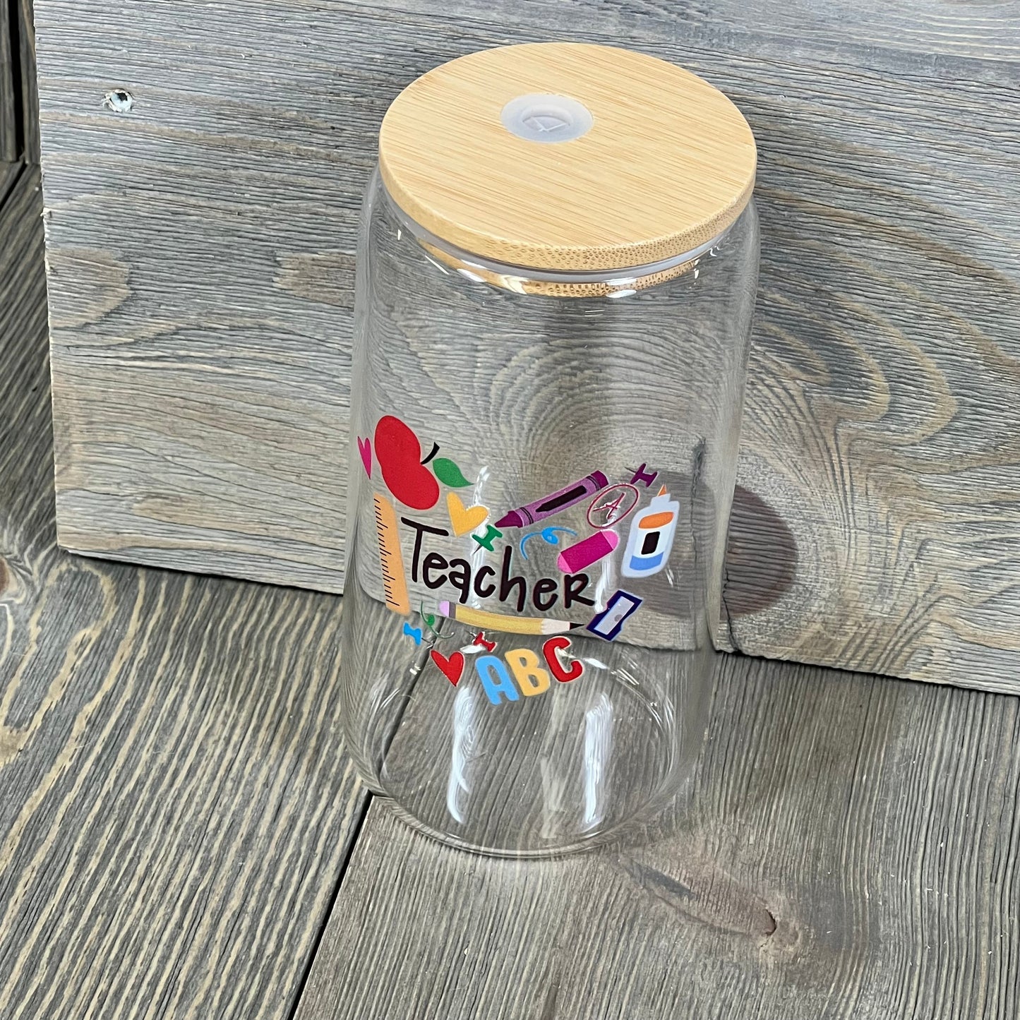 Teacher appreciation glass cup with colorful design, bamboo lid, and straw. Perfect 16 oz gift for Teachers Week.