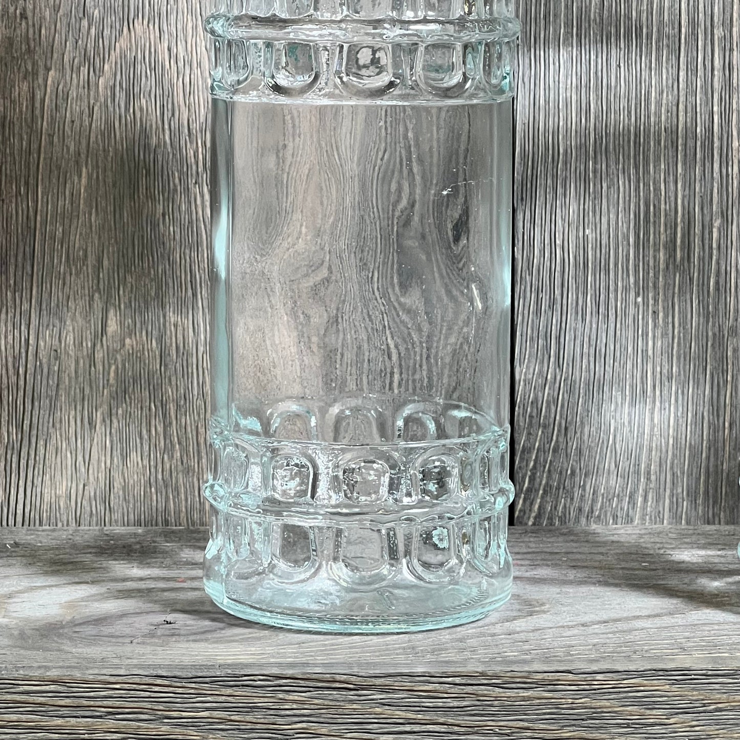 Clear glass bottle with textured design, featuring a cork top. Ideal for storage or decoration, 16oz capacity.