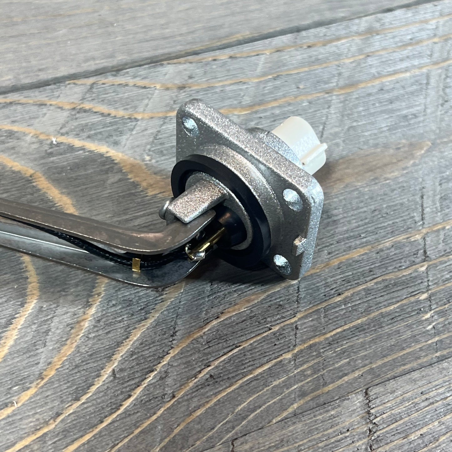 Close-up of Flynsu engine oil level sensor 8949150030, compatible with Lexus GS430 and LS430, on a wooden surface.