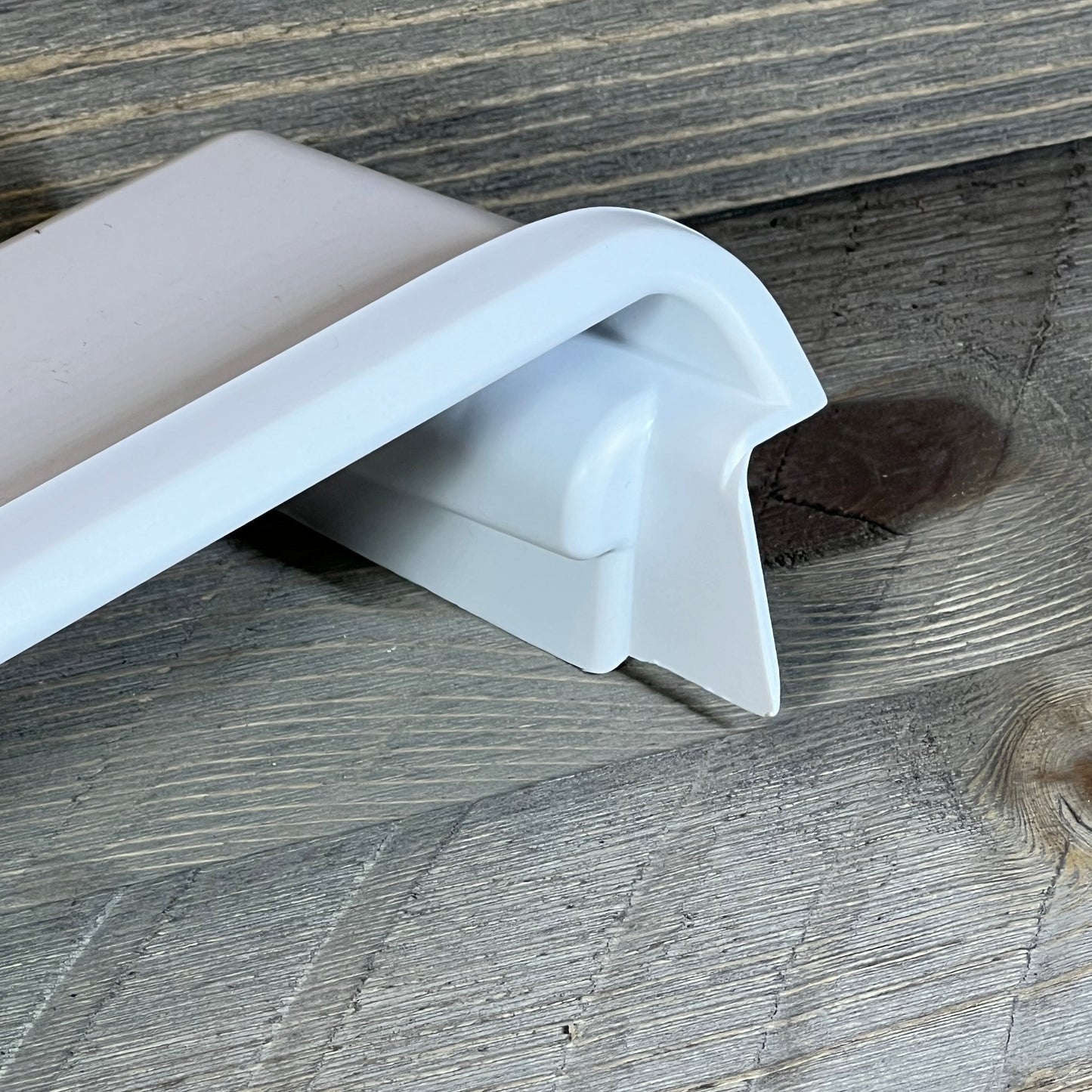 Close-up of Frigidaire 241511706 refrigerator door shelf bin corner, showcasing durable plastic construction.