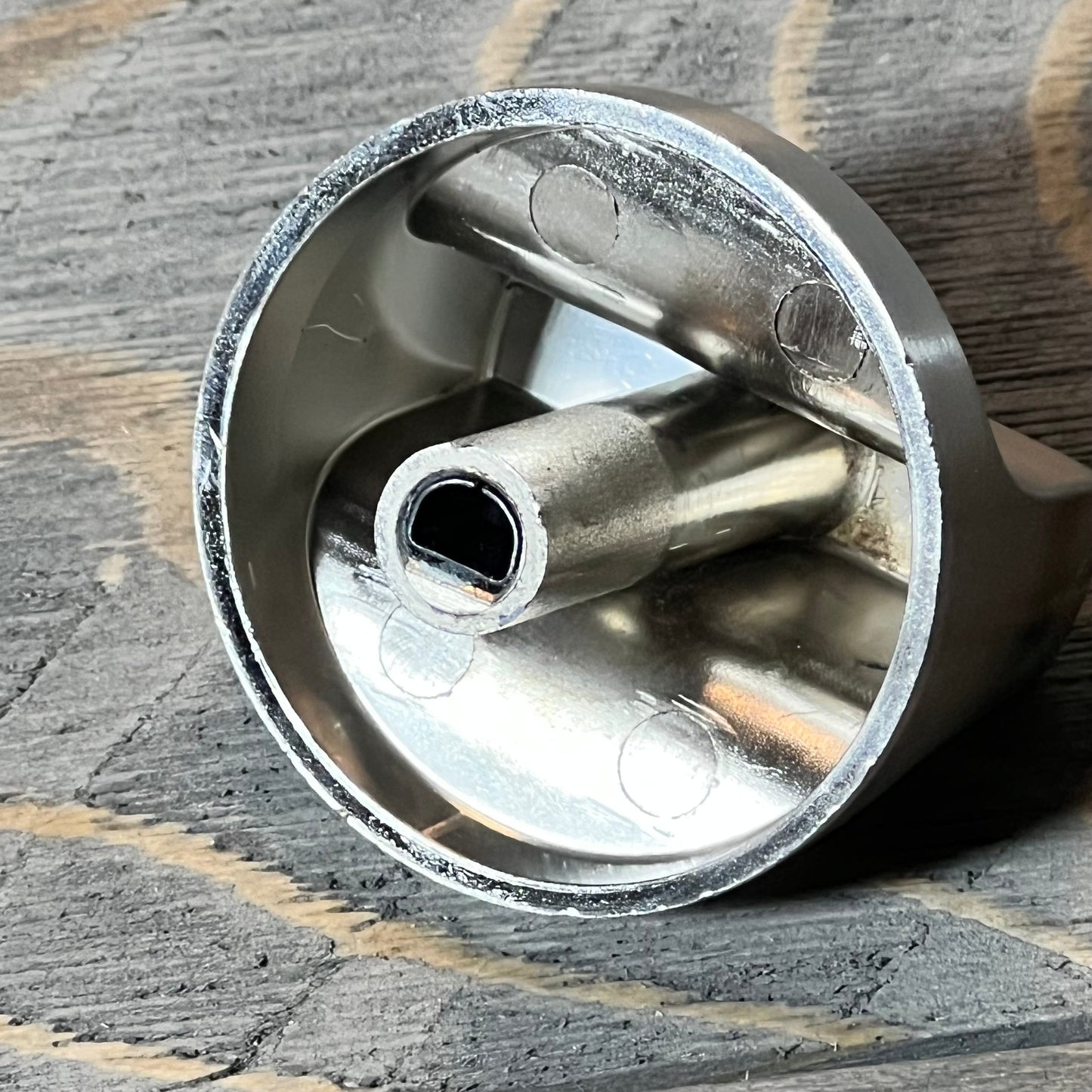 Close-up of stainless steel knob for Whirlpool gas range, highlighting inner design and durability features.