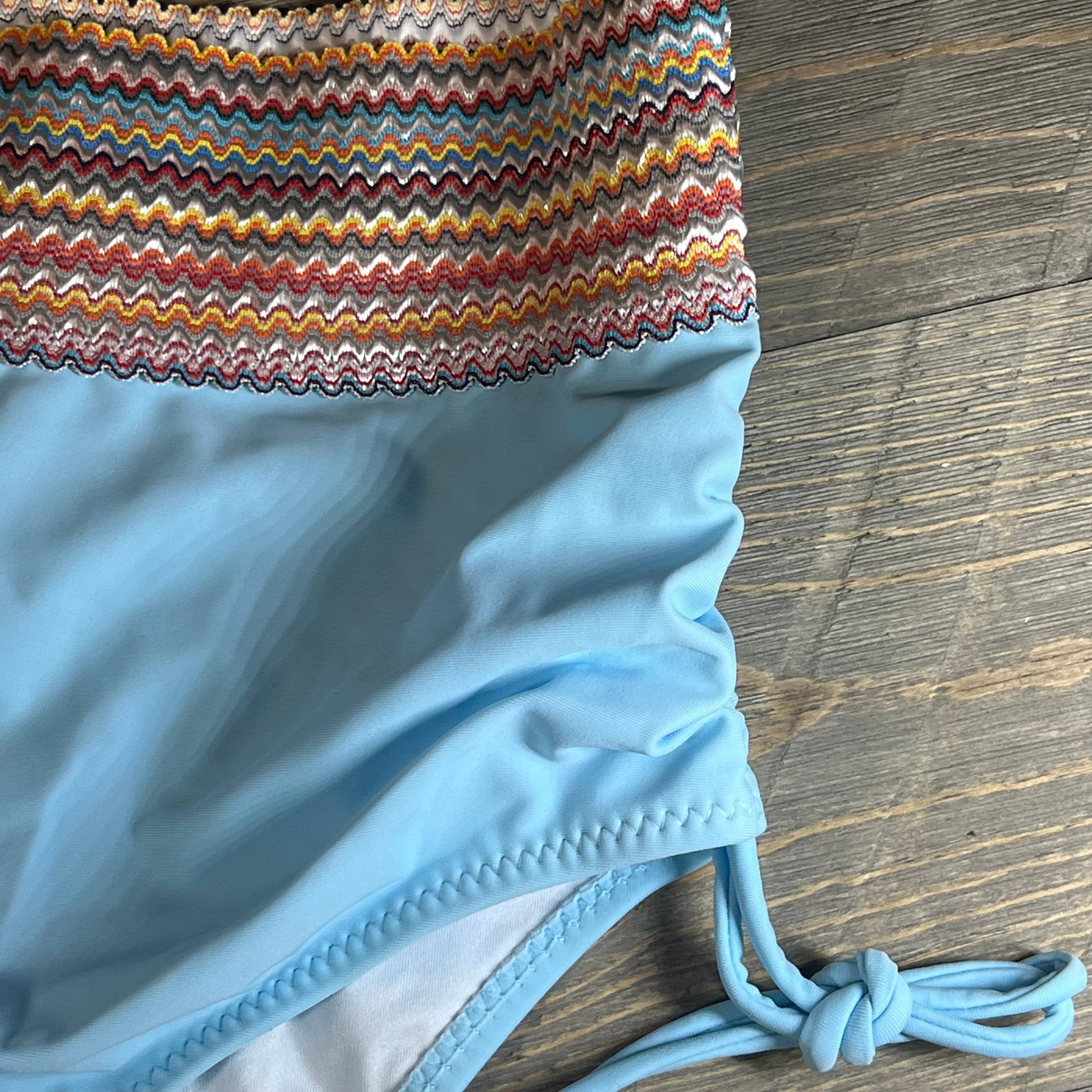 Colorful zigzag pattern top with light blue high-waisted bikini bottom featuring side ties, perfect for summer style.