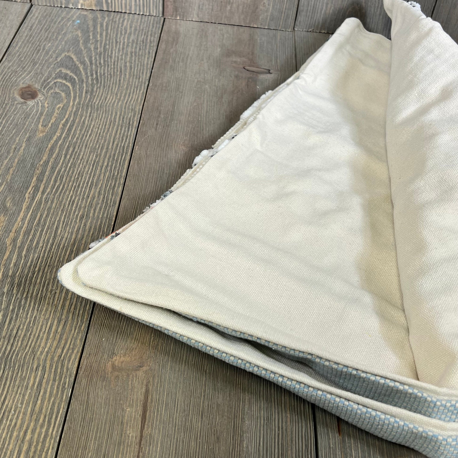 Boho throw pillow cover in neutral tones, showcasing soft chenille texture and durable stitching on a wooden surface.