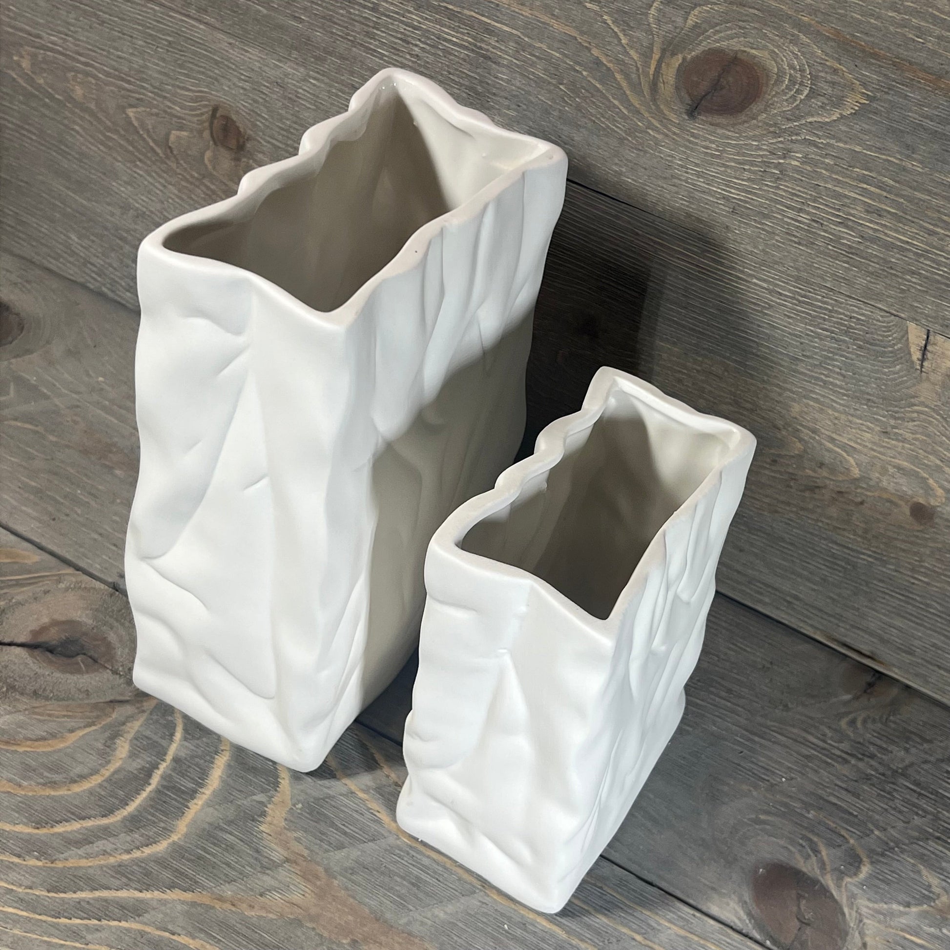 Crinkle Paper Bag Ceramic Vase in a creamy coconut café finish, showcasing a textured modern design on wood background.