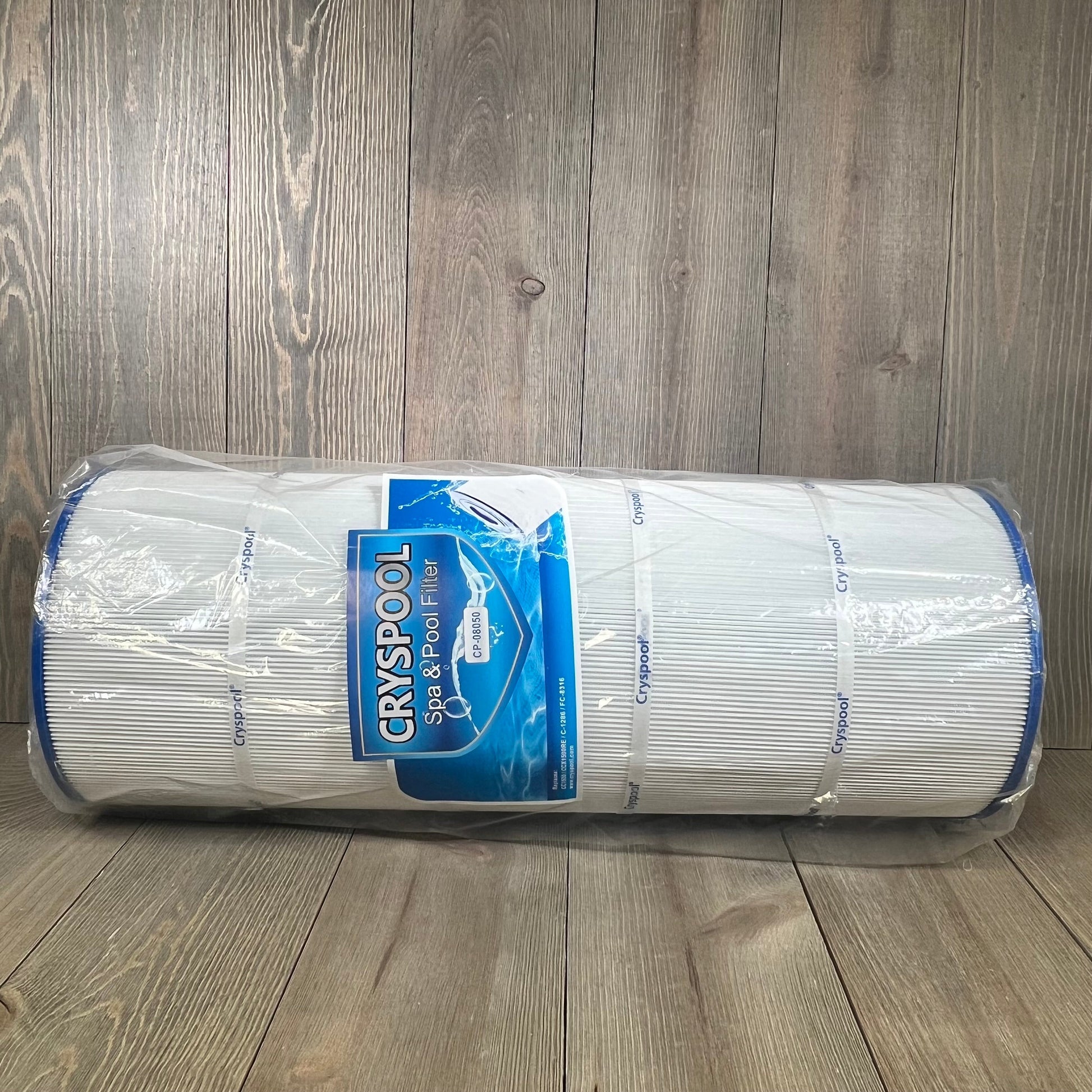 Cryspool 08050 pool filter cartridge, compatible with Hayward systems, wrapped in packaging, on a wooden surface.