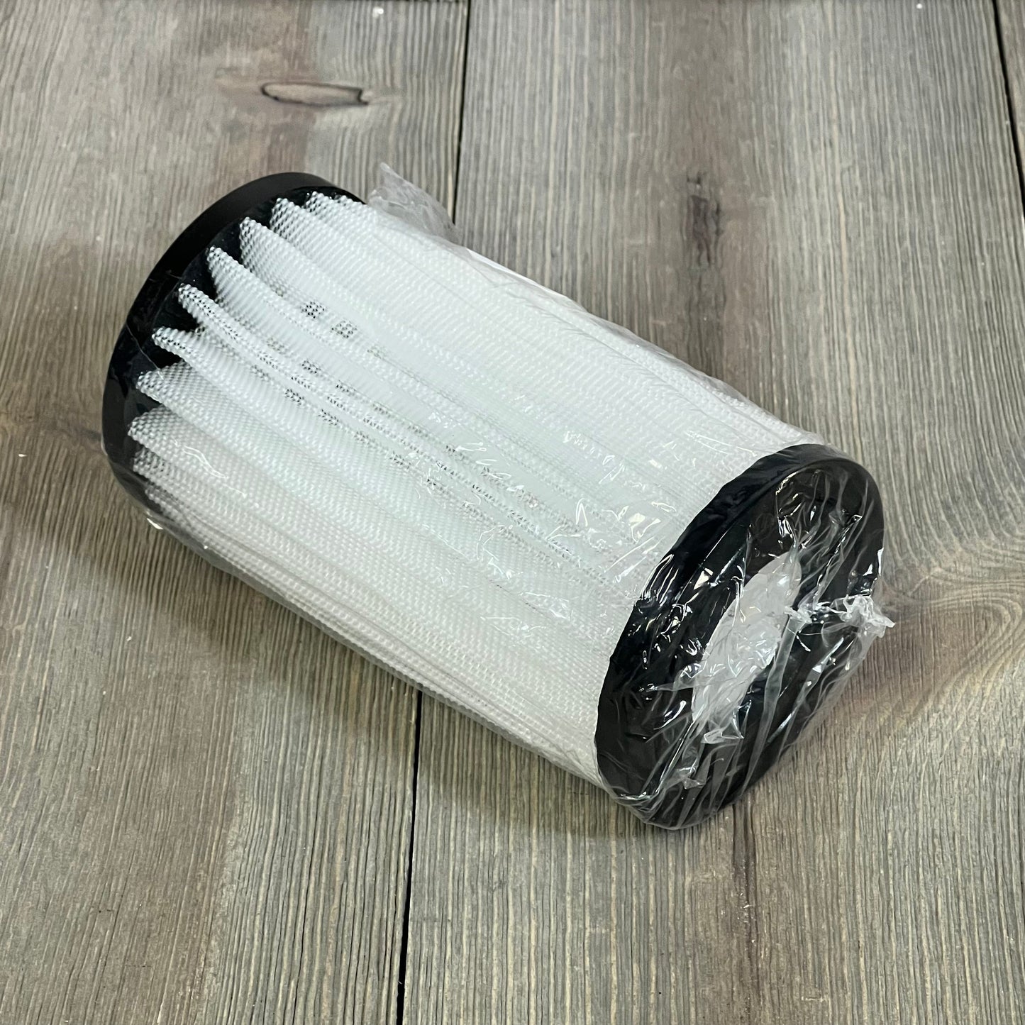 Energy filter element for Zodiac Jandy pool cleaner, wrapped in plastic, shown on a wooden surface.