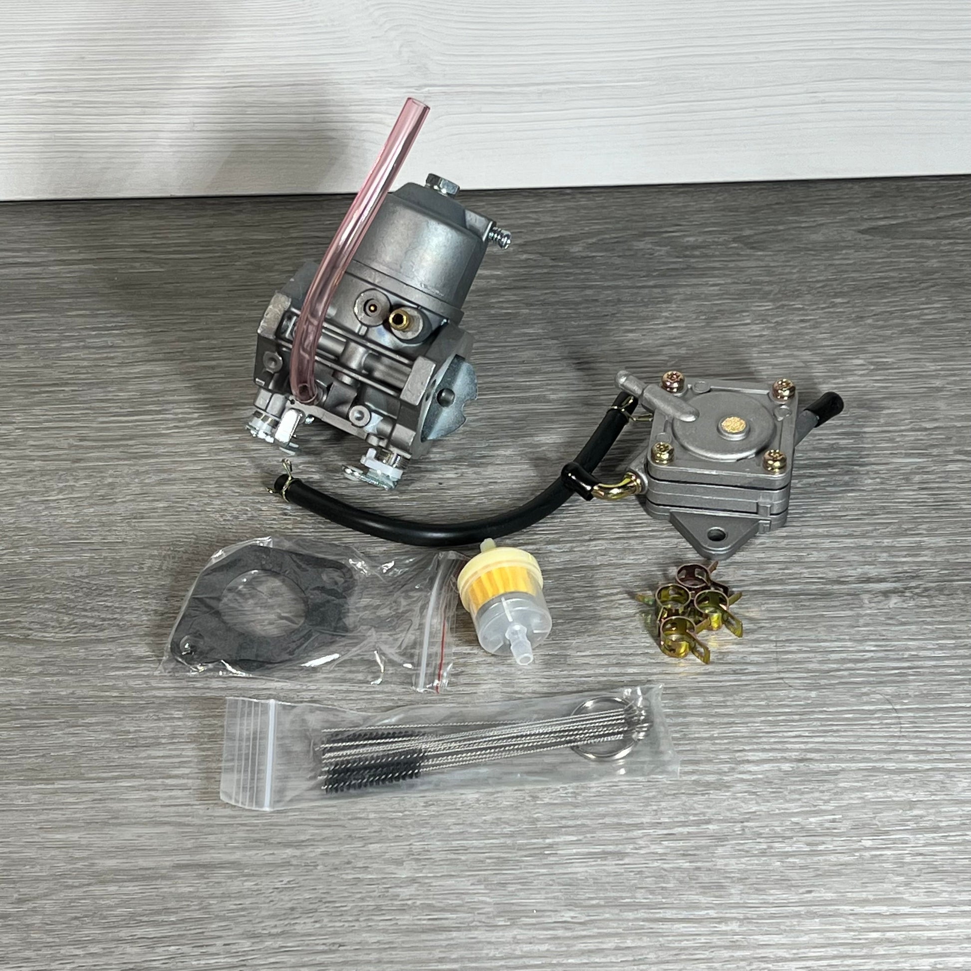 Cylinman carburetor with accessories for John Deere mowers, featuring durable metal components on a wooden surface.
