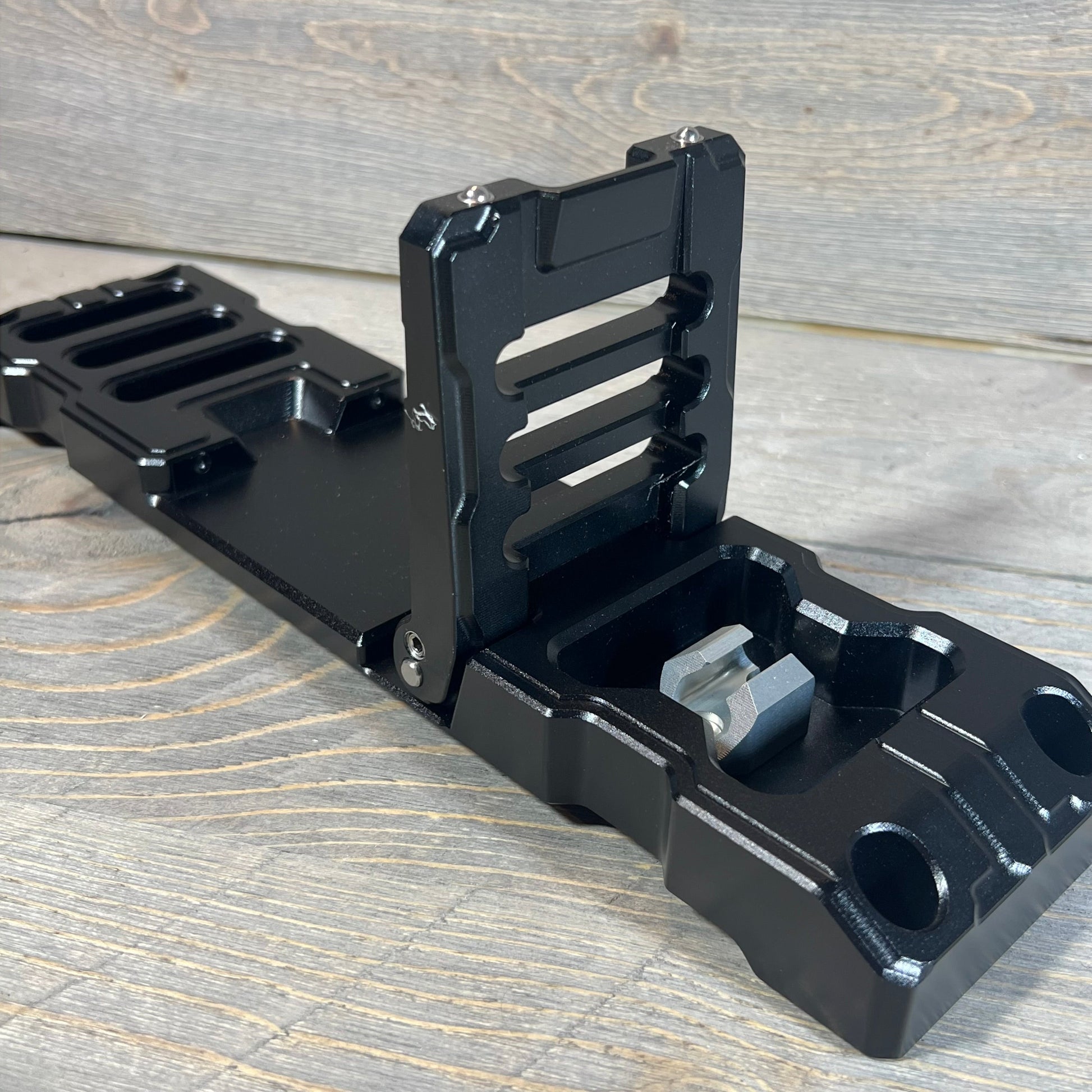 Durable black aluminum alloy door hinge step for Jeep Wrangler & Gladiator 2007-2023, shown on a wooden surface.