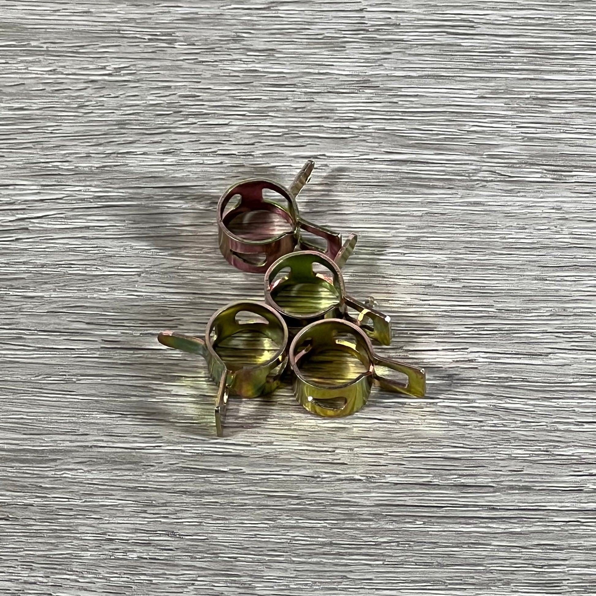 Durable clamps for Cylinman Carburetor, compatible with John Deere GS75 HD75 mowers, on textured surface.