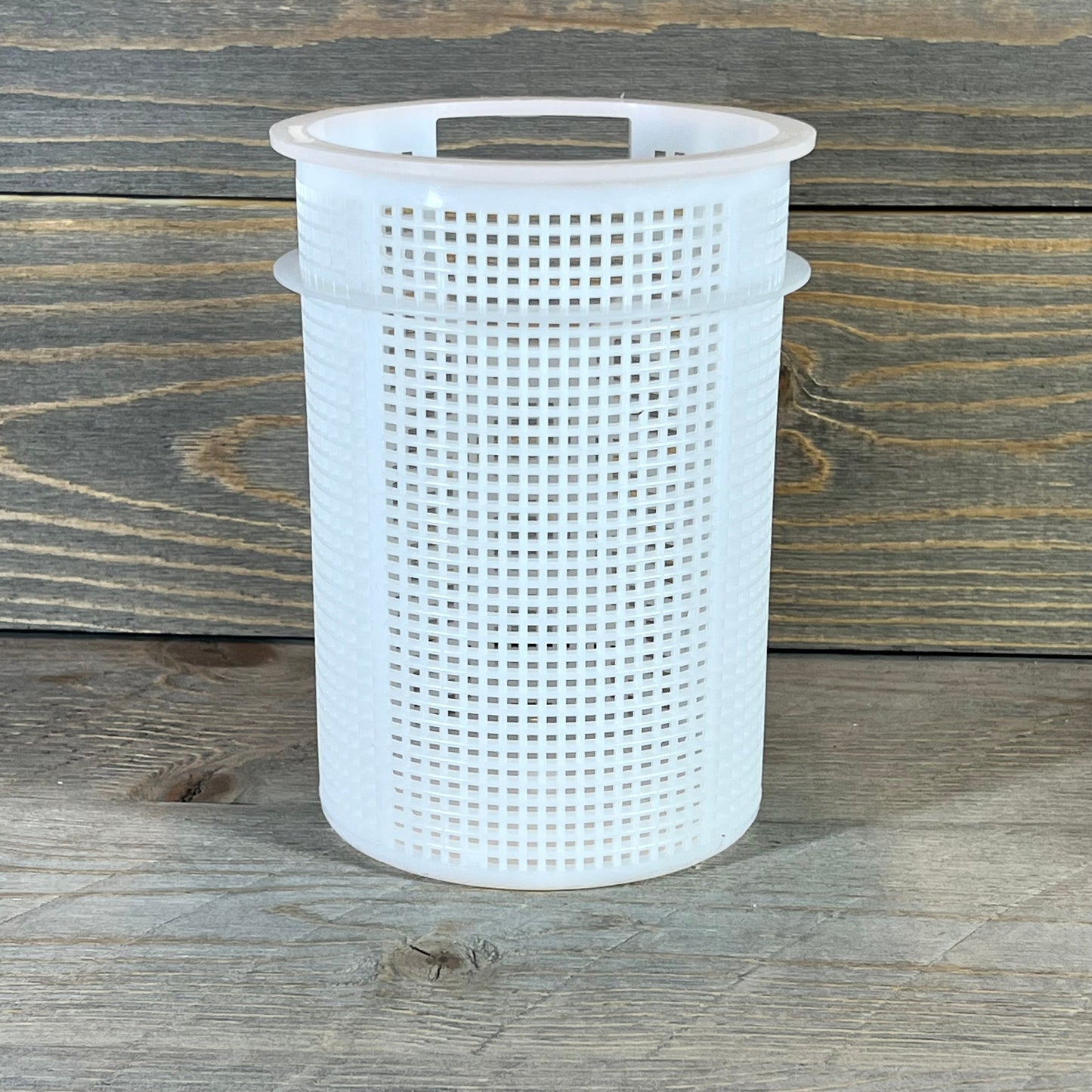 Durable Pentair strainer basket for Sta-Rite suction trap assembly on wooden background.