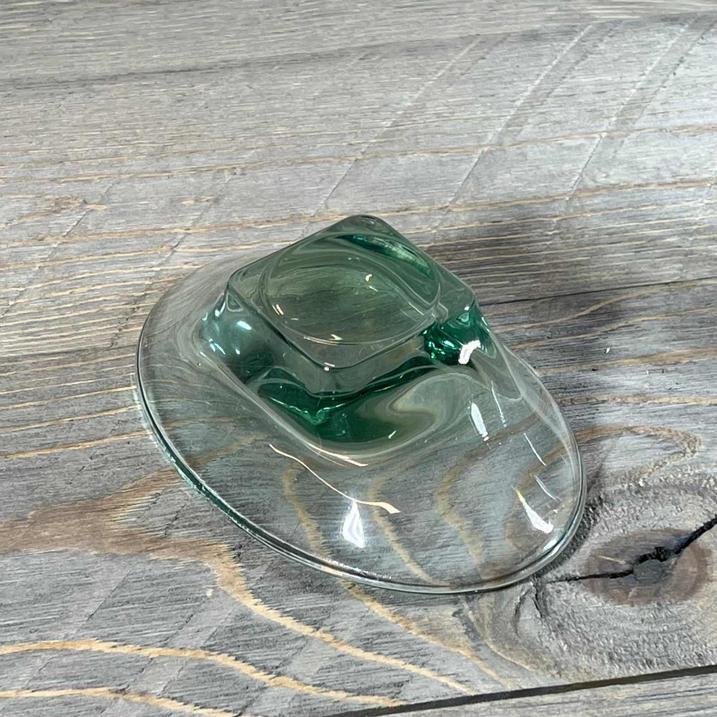 Elegant green teal glass soap dish from a 5-piece bathroom accessory set displayed on rustic wood surface.