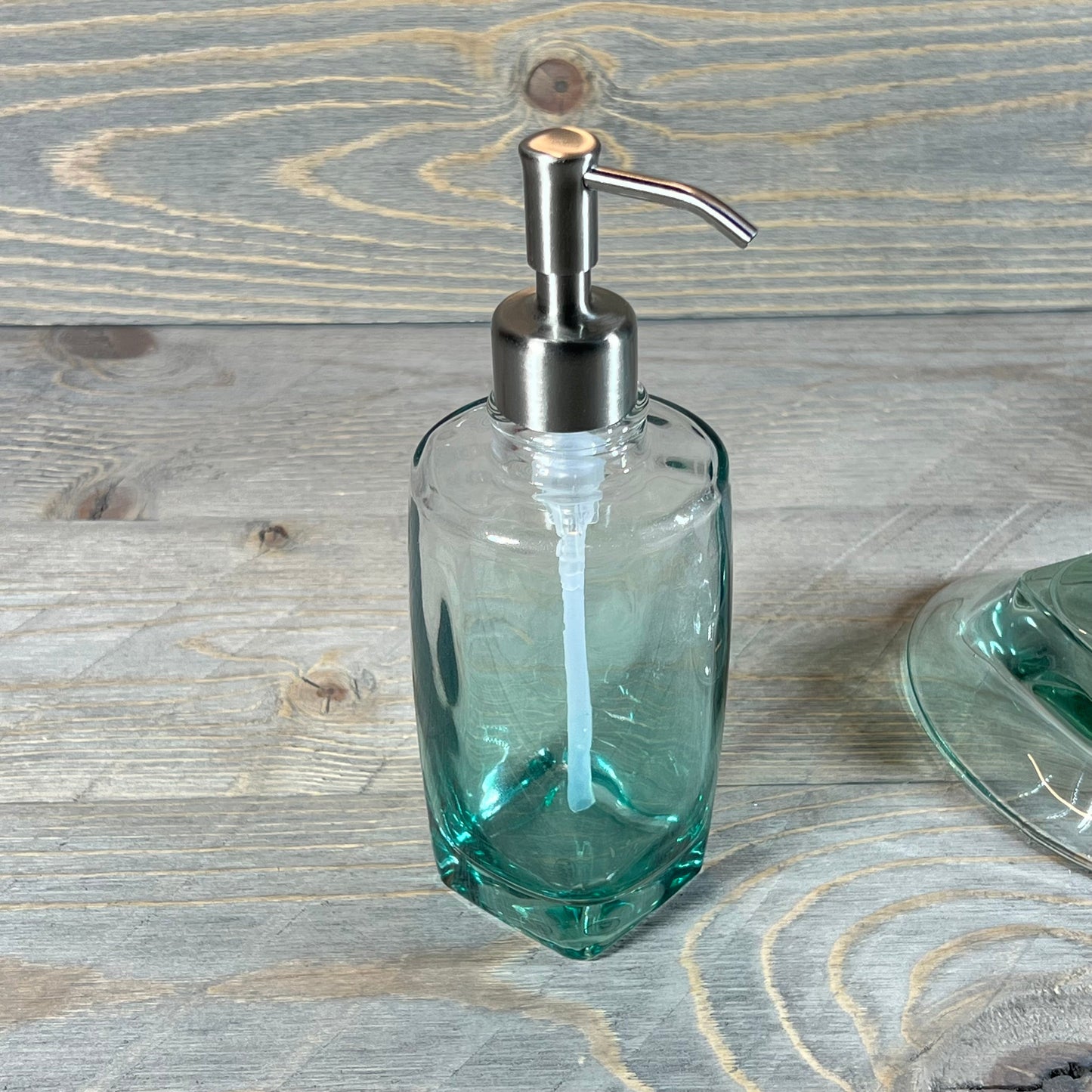 Elegant green teal glass soap dispenser with silver pump from the 5-piece bathroom accessory set.