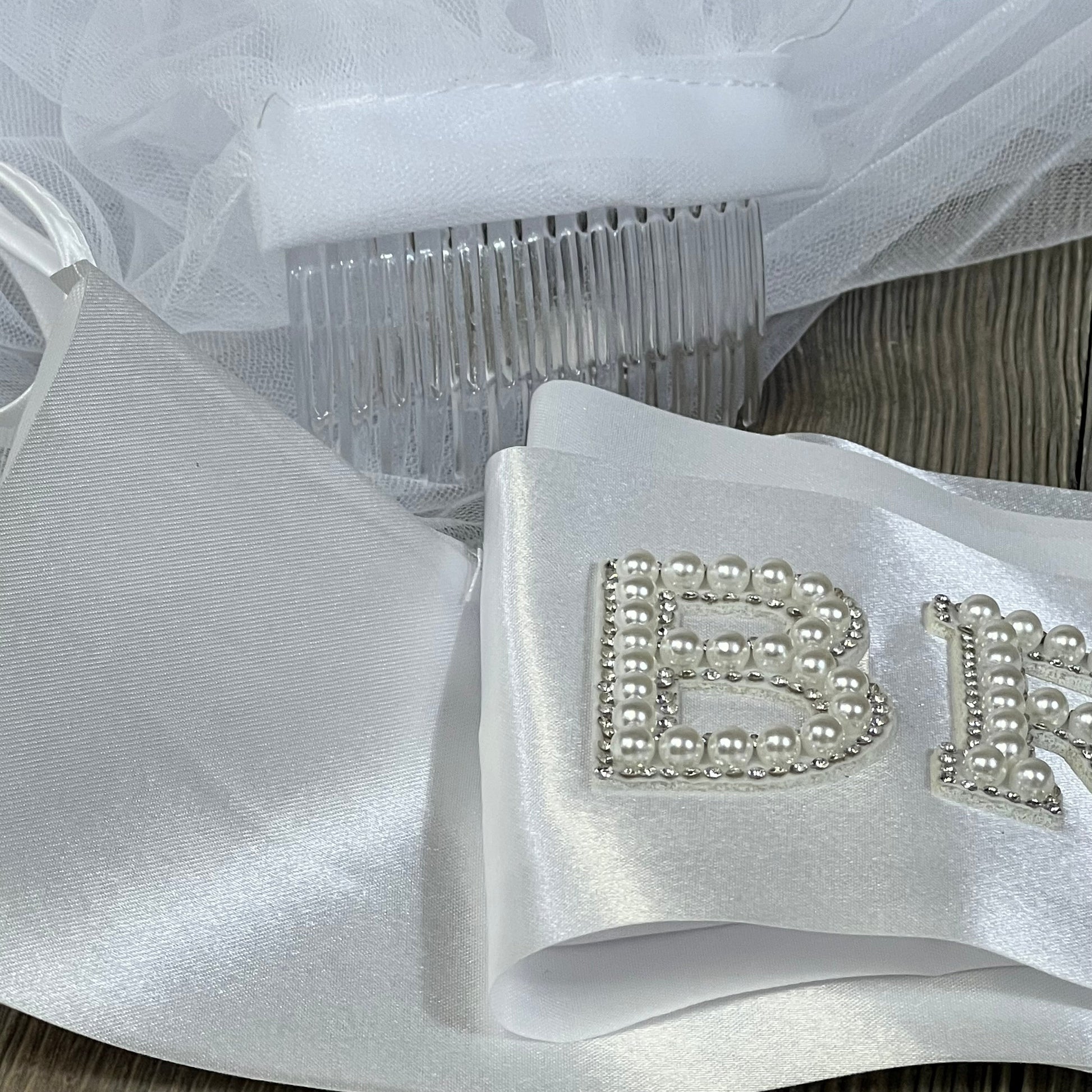 Elegant wedding package featuring a pearl-studded bridal sash and delicate veil with a comb, perfect for brides.