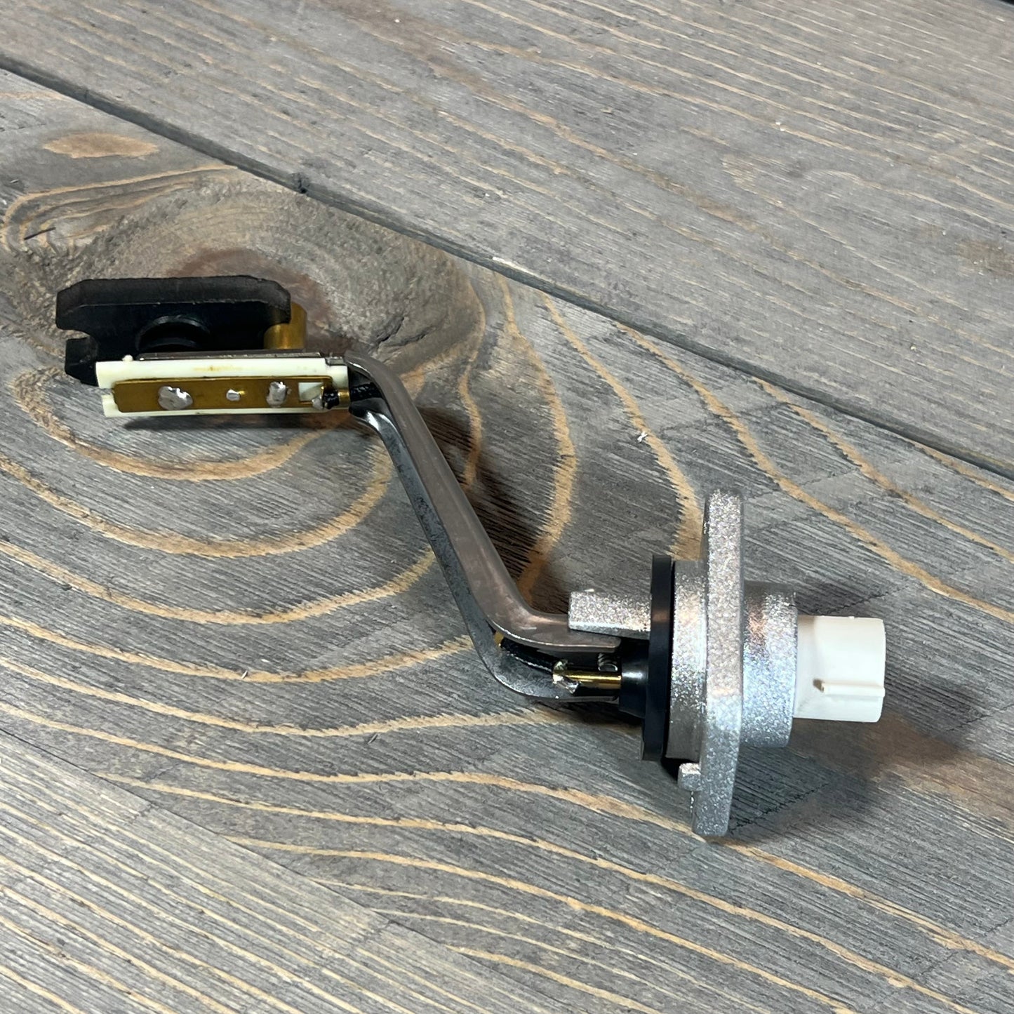 Engine oil level sensor for Lexus GS430 2006-2007 on wooden surface, showcasing metal finish and connector.
