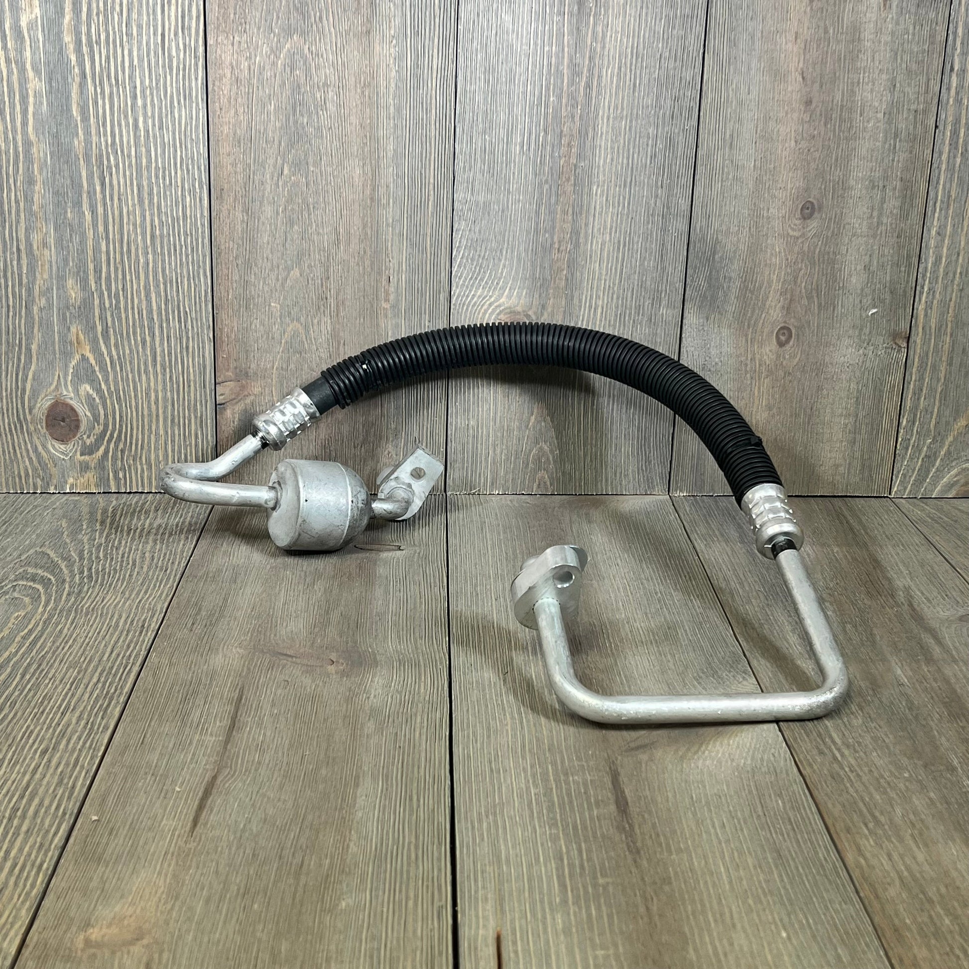 A-Premium A/C discharge line hose assembly for Ford Explorer 2013-2019, shown on a wooden surface, durable metal design.