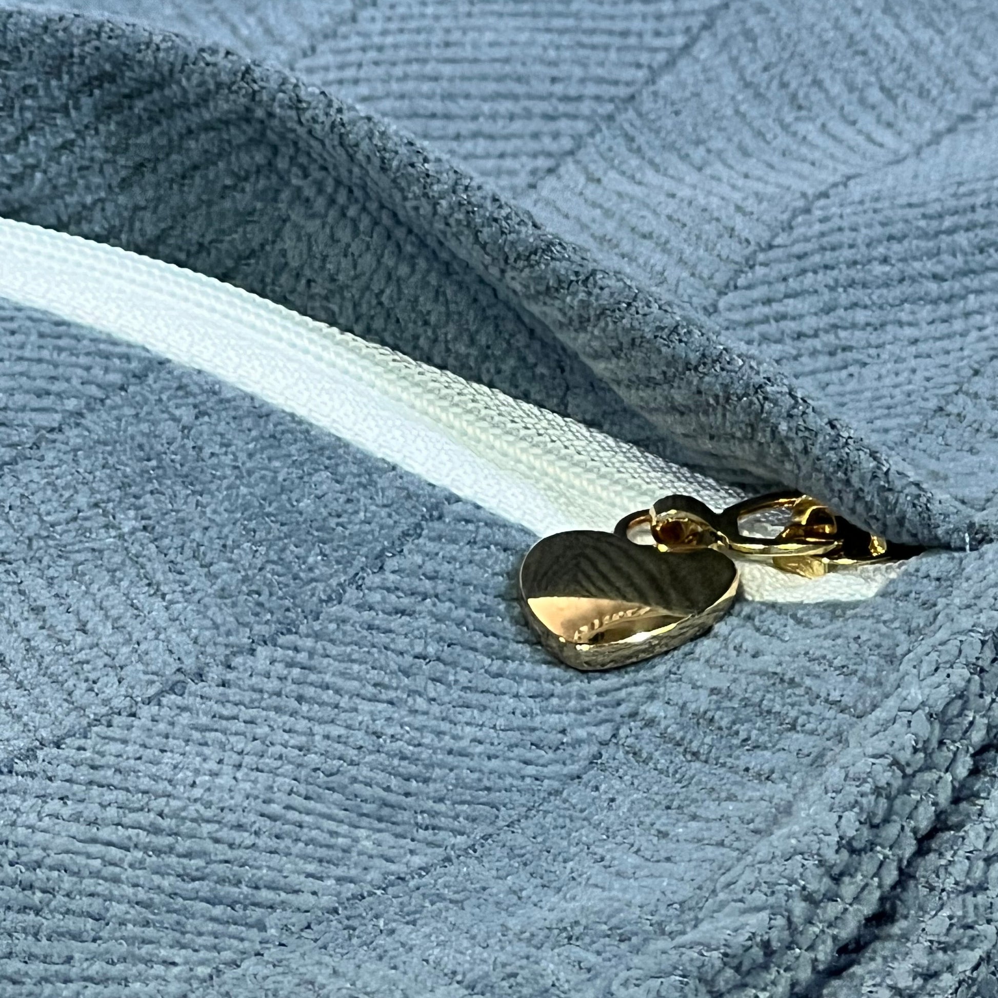 Dusty blue chenille pillow cover with gold heart zipper, showcasing luxury texture and elegant design for home decor.