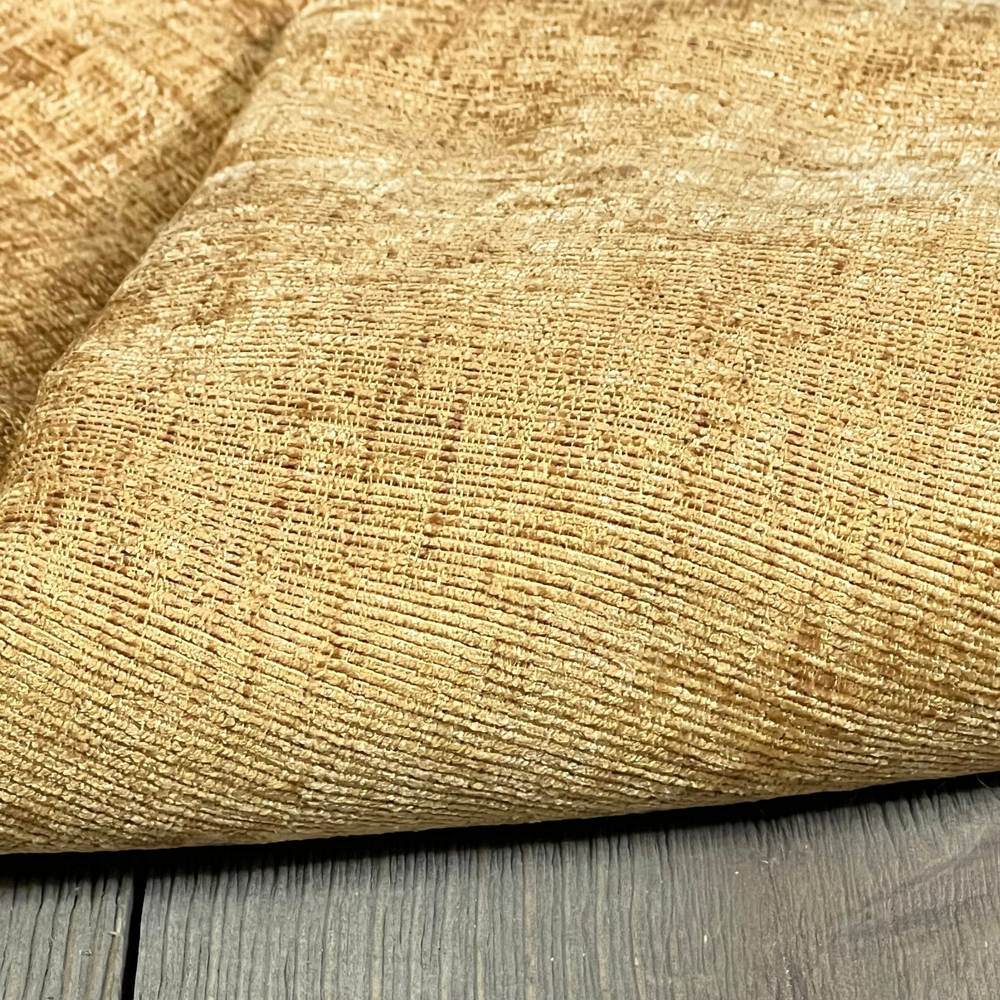 Cozy gold chenille texture of CaliTime throw pillow covers on a wooden surface, ideal for enhancing living room decor.