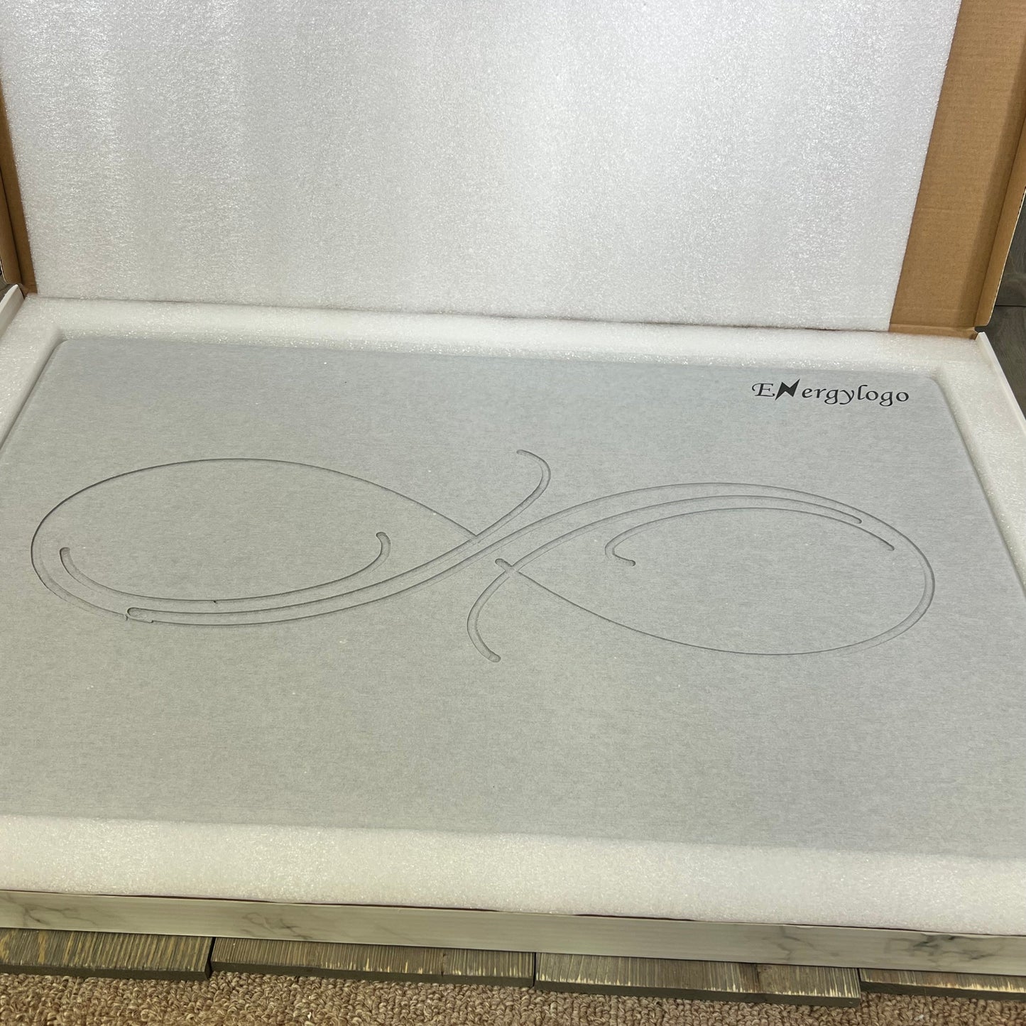 Grey Infinity ENERGYLOGO stone bath mat, showcasing elegant design, non-slip surface, and quick-drying diatomaceous earth material.