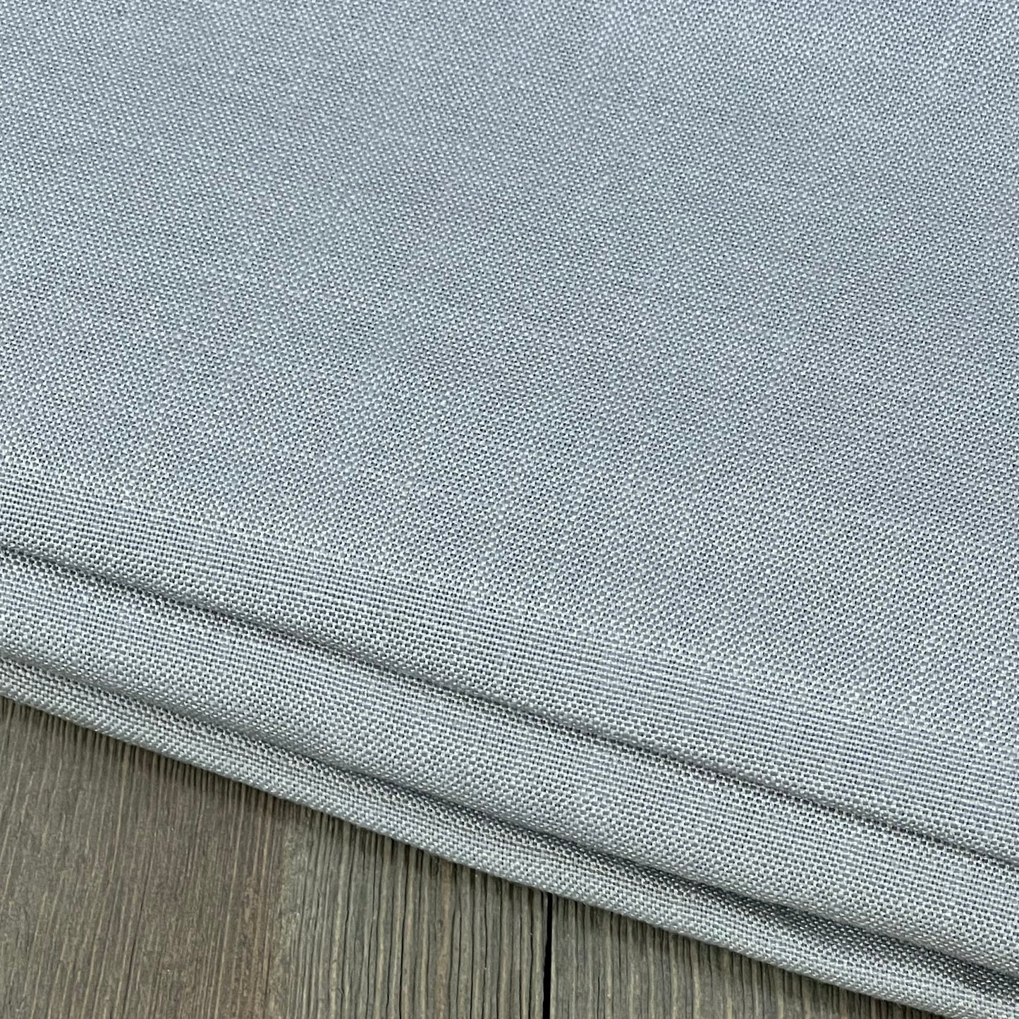 Linen textured grey tablecloth showcasing its premium, spill-proof, waterproof, and wrinkle-free design on a wooden surface.
