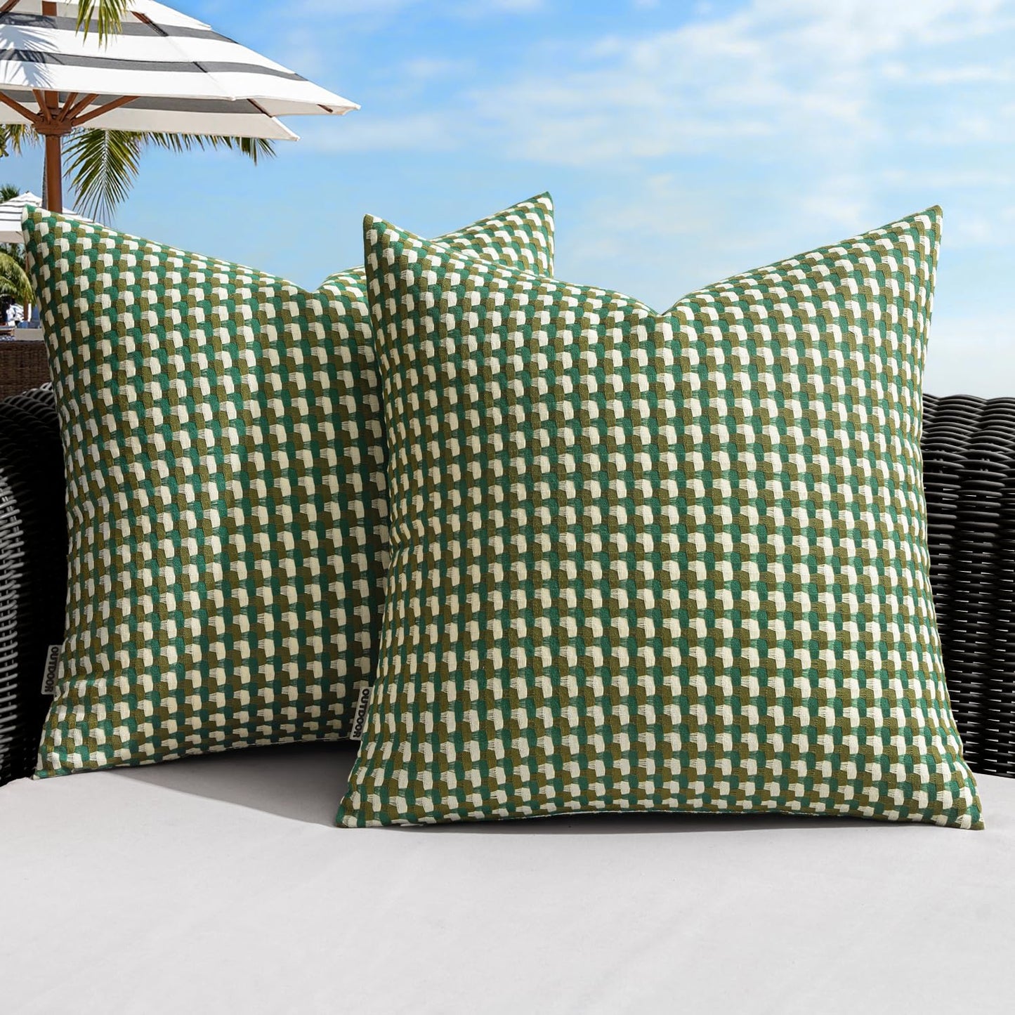 Green farmhouse-style outdoor pillow covers on a patio sofa, perfect for garden and balcony decor, 18x18 inch, waterproof.