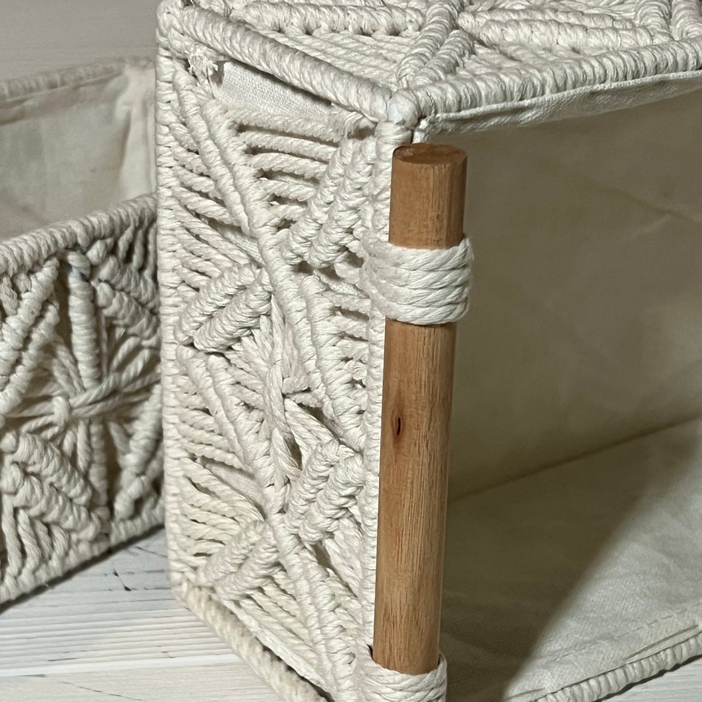 Handwoven ivory white macrame storage baskets with wooden accents, perfect for bathroom or bedroom decor.