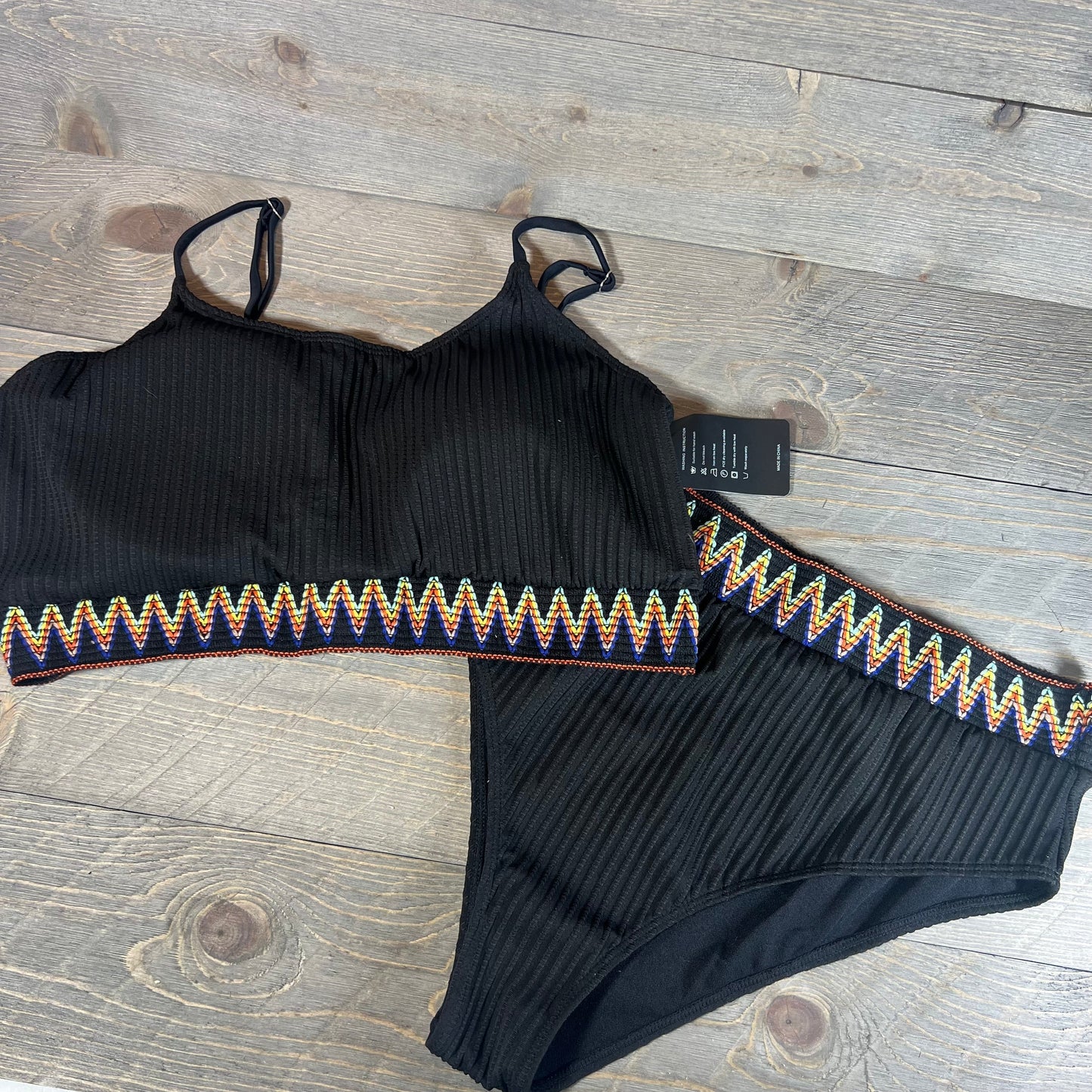 High waisted ribbed bikini set with colorful zigzag trim on a wooden background, size XXL.