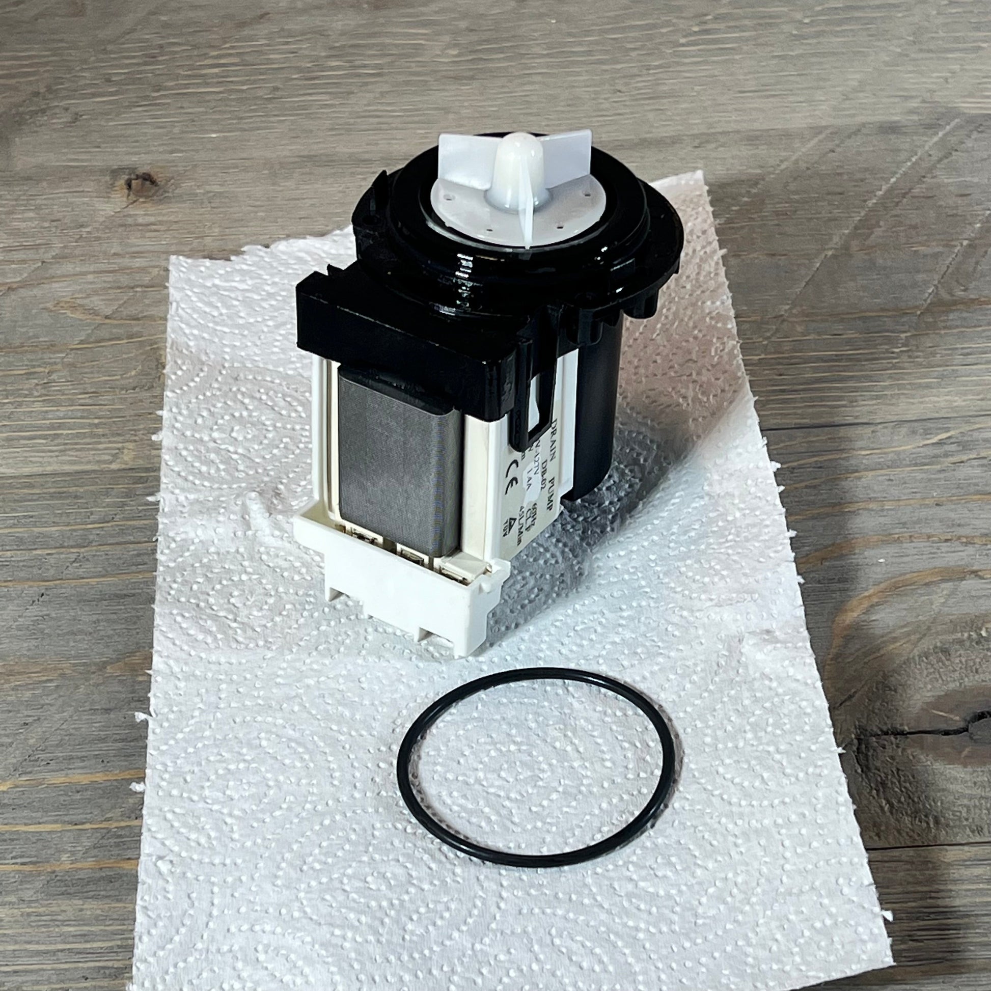 Kenmore & LG washer drain pump motor shown on paper towel with gasket ring included.