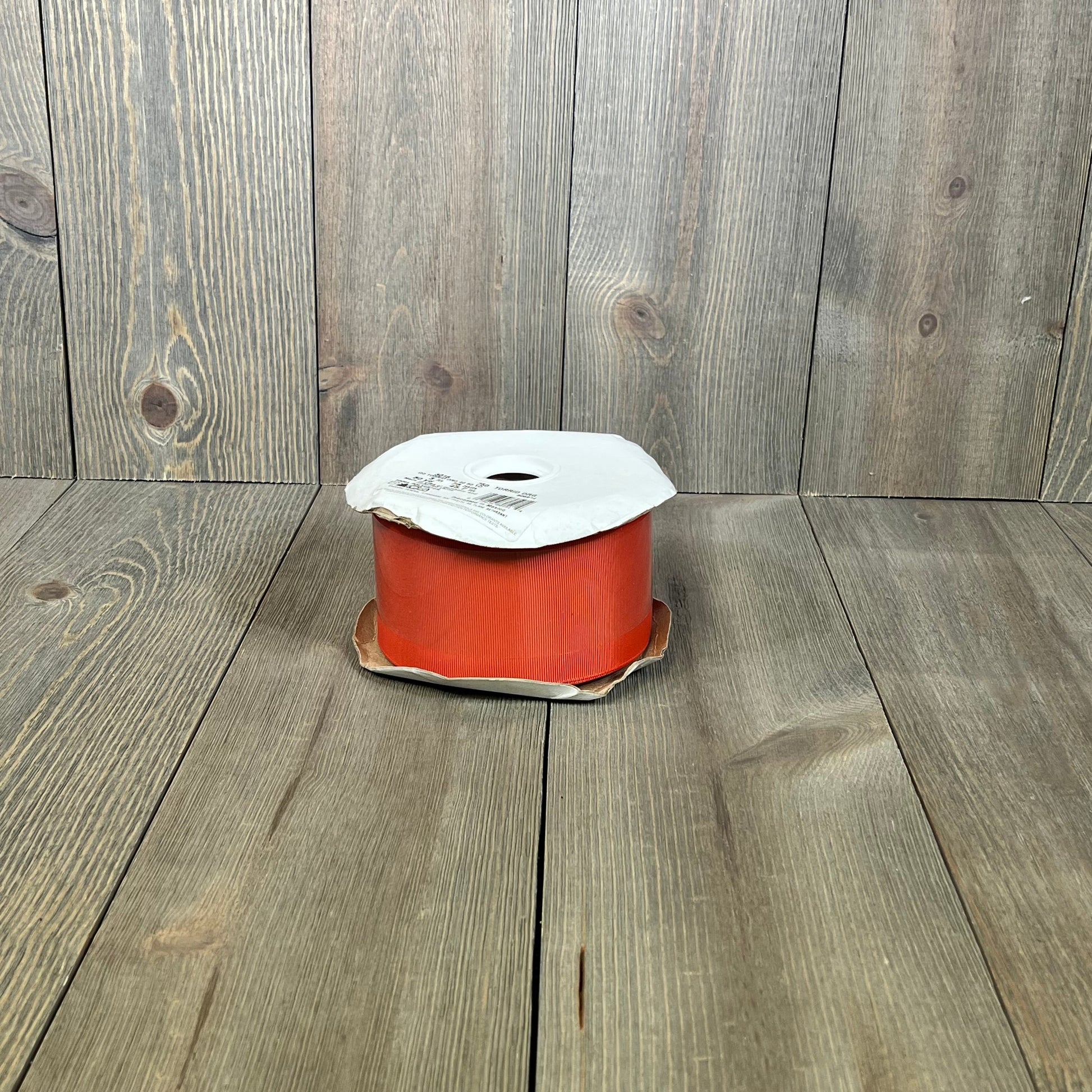 Vibrant 3" torrid orange grosgrain ribbon, 50 yards, perfect for crafts and decorations, displayed on a wooden surface.