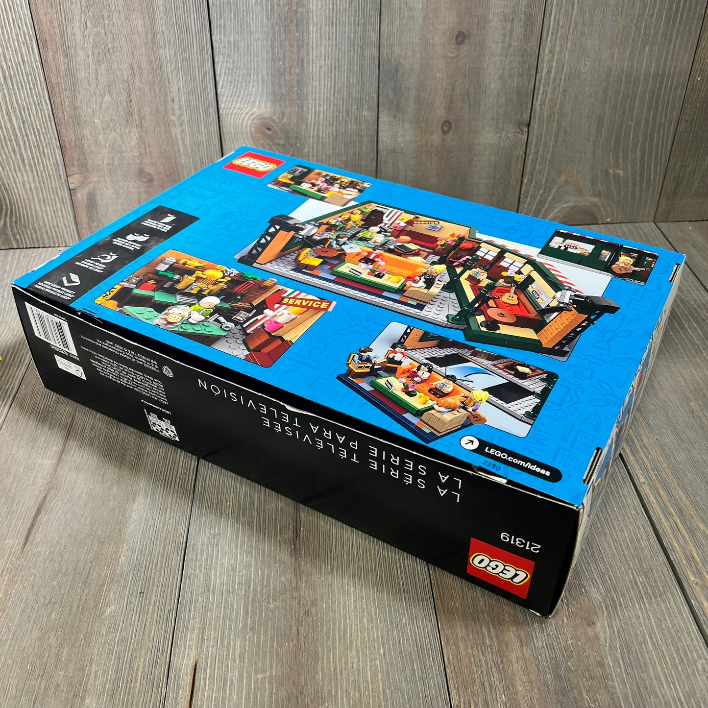 Friends Lego Box packaging showcasing colorful assembly scenes on a wooden surface.