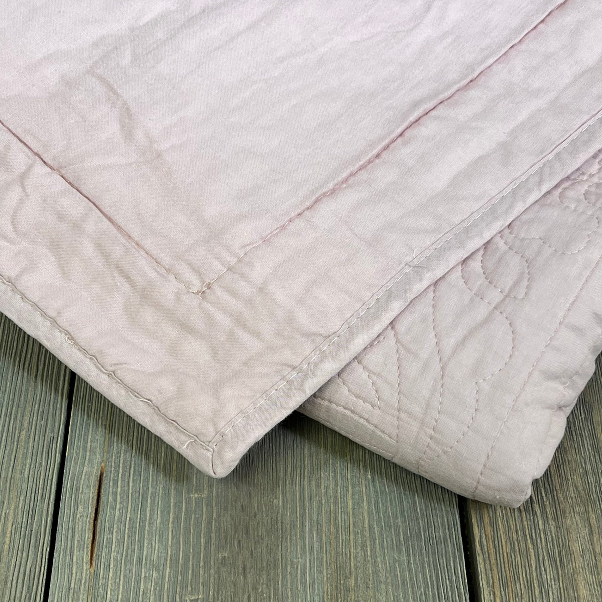 Dusty pink cotton quilted pillow sham with floral print, offering a soft, elegant touch to any bedroom decor.