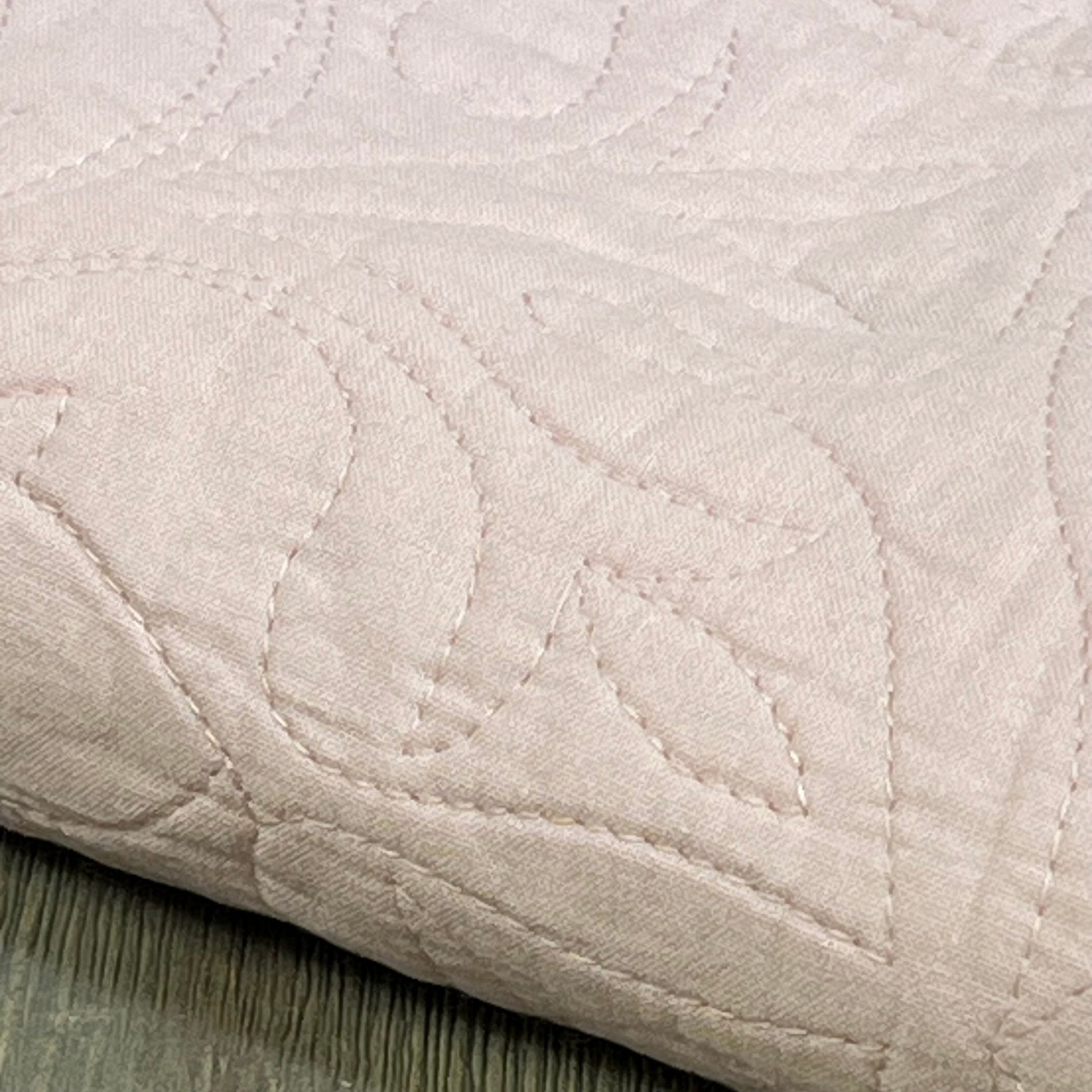 Dusty pink floral quilted pillow sham, 100% cotton, showcasing intricate stitching and soft texture.