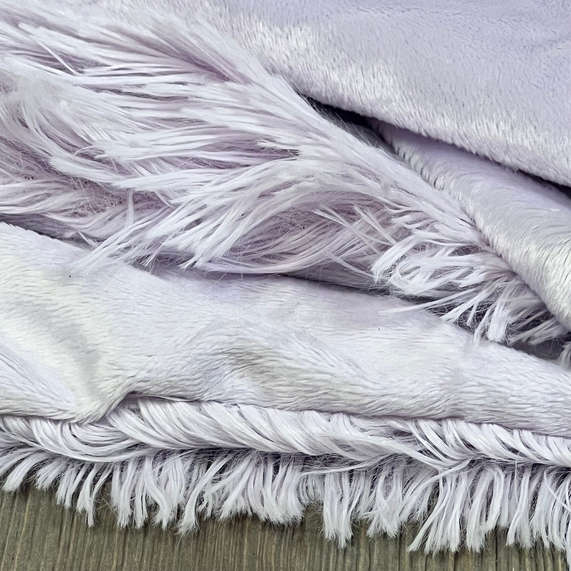 Light purple faux fur pillowcases with shaggy texture, showcasing plush softness and fluffy lavender details.