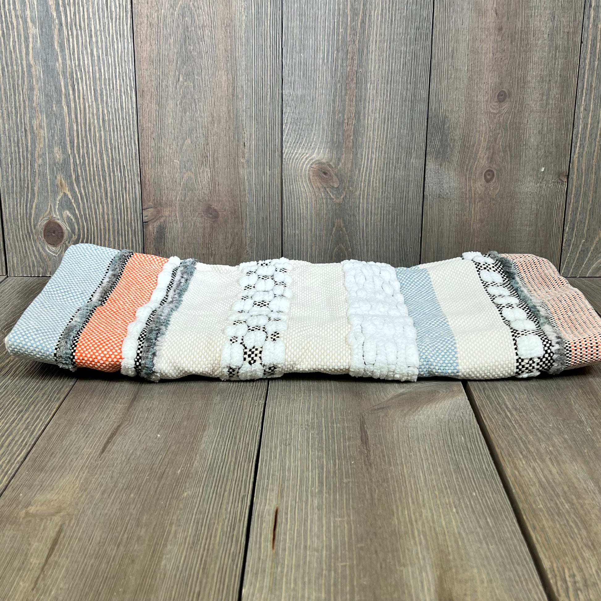 Boho throw pillow cover with orange and blue stripes, featuring textured chenille and farmhouse design on wooden background.