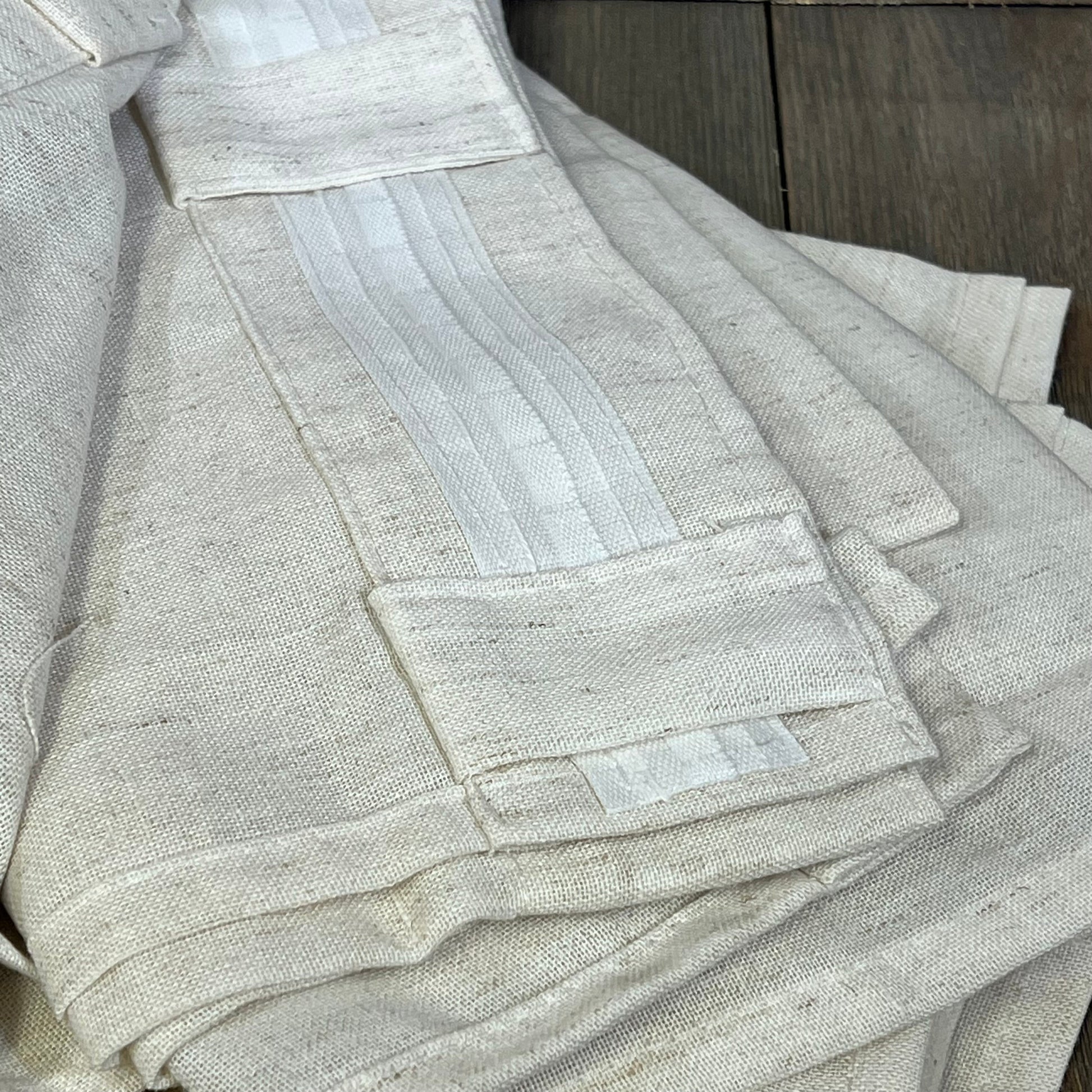 Cream beige linen sheer curtains with pleat hooks, showcasing fabric texture for bedroom or living room decor.