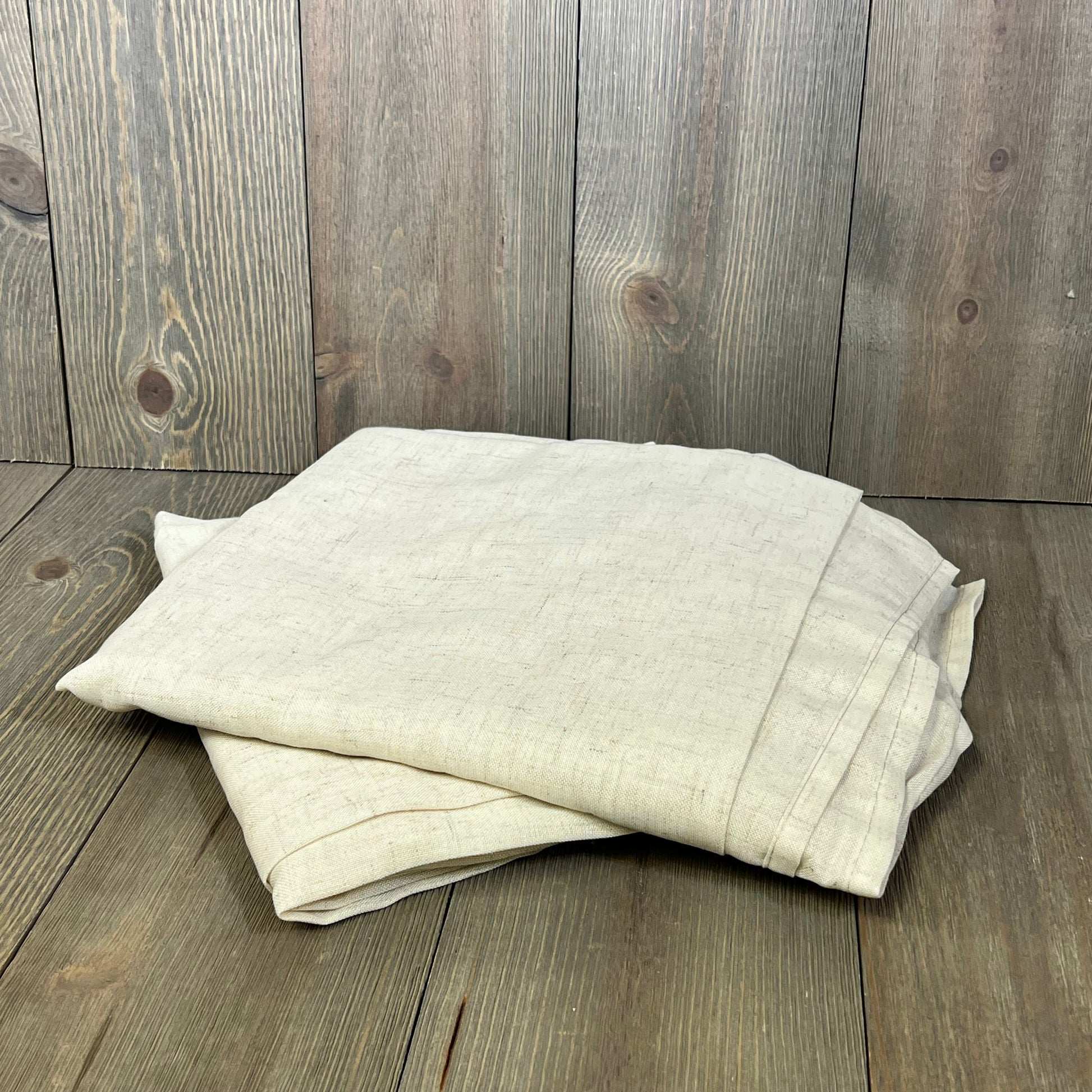 Beige ChrisDowa blackout curtains folded on wooden floor, showcasing thermal insulation and room darkening features.