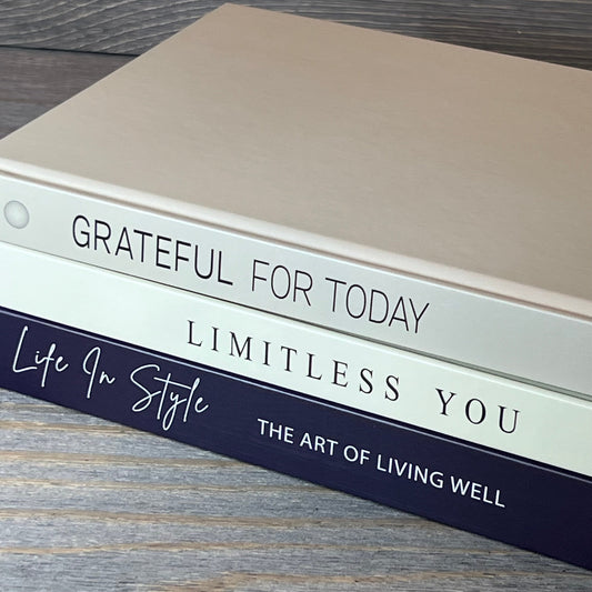 Navy blue and white decorative books stacked on a wooden surface, perfect for enhancing home decor and shelf styling.