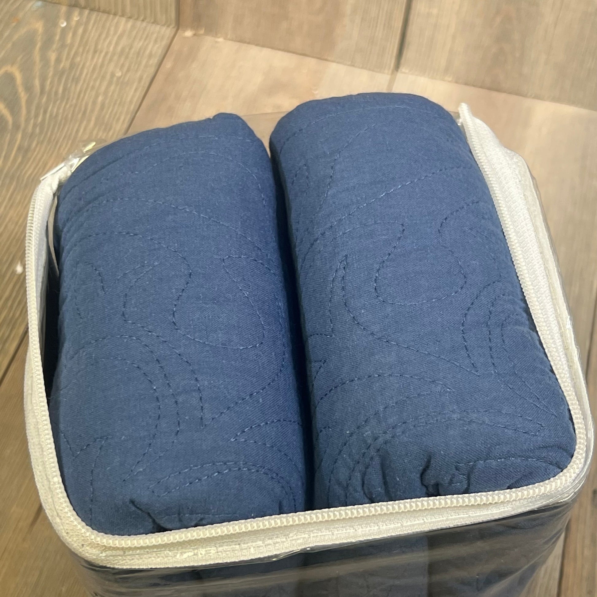 Navy blue quilted pillow shams in clear packaging, showcasing floral print and 100% cotton material for king size beds.