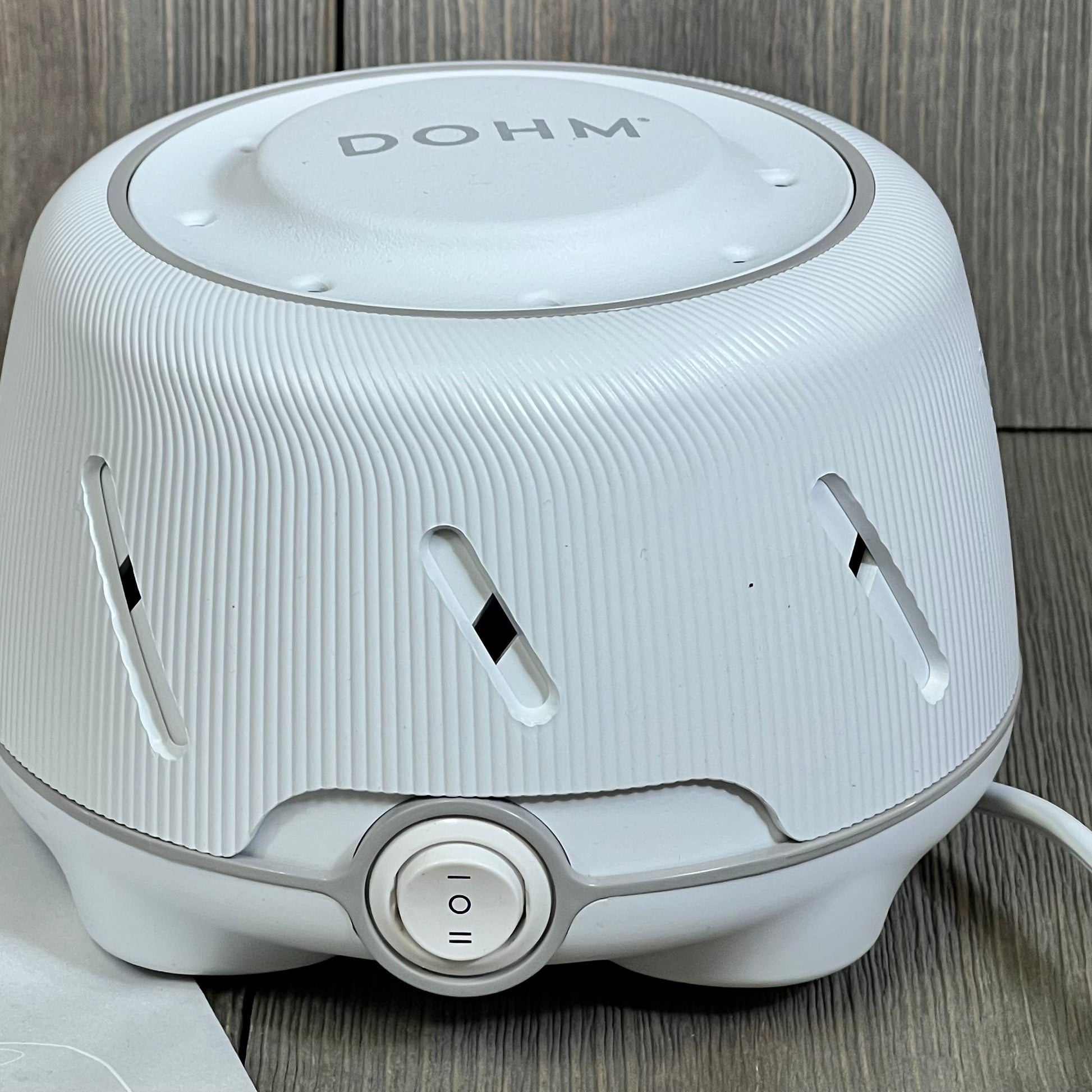 White Yogasleep Dohm noise machine with fan, ideal for sleep aid and office privacy. White and gray design.