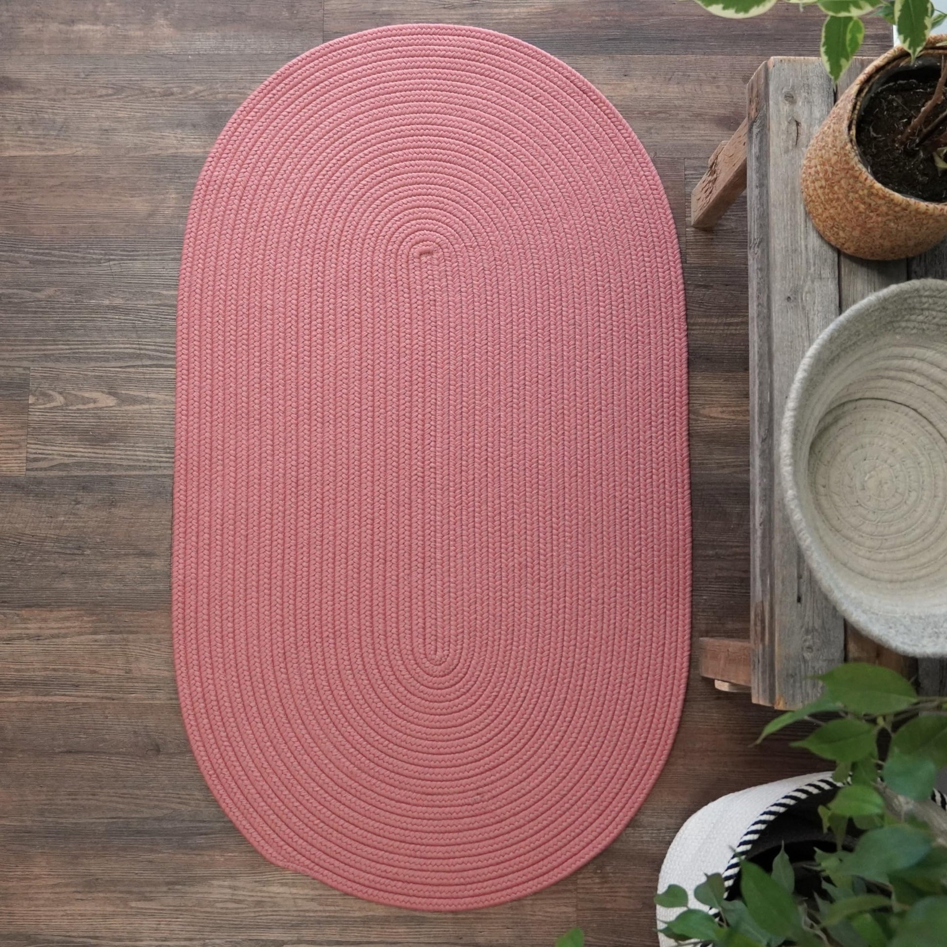 Handcrafted rusted red braided reversible runner rug on wood floor, ideal for high traffic areas like entryways and kitchens.
