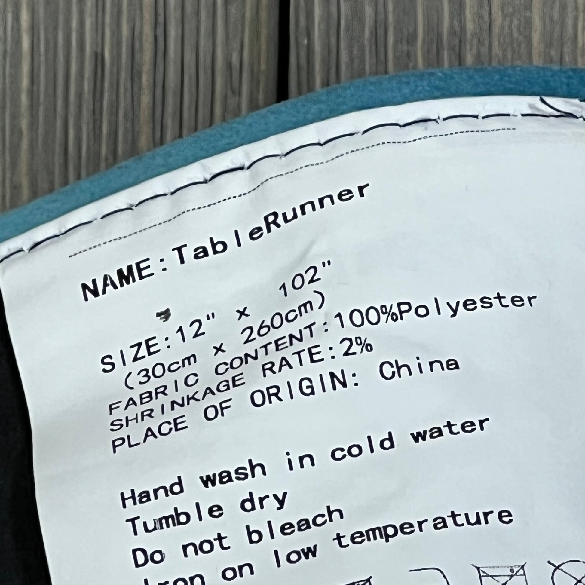 Care label for Designer French Elegant Wild Flowers Velvet Table Runner, 12"x102", polyester fabric, washing instructions.