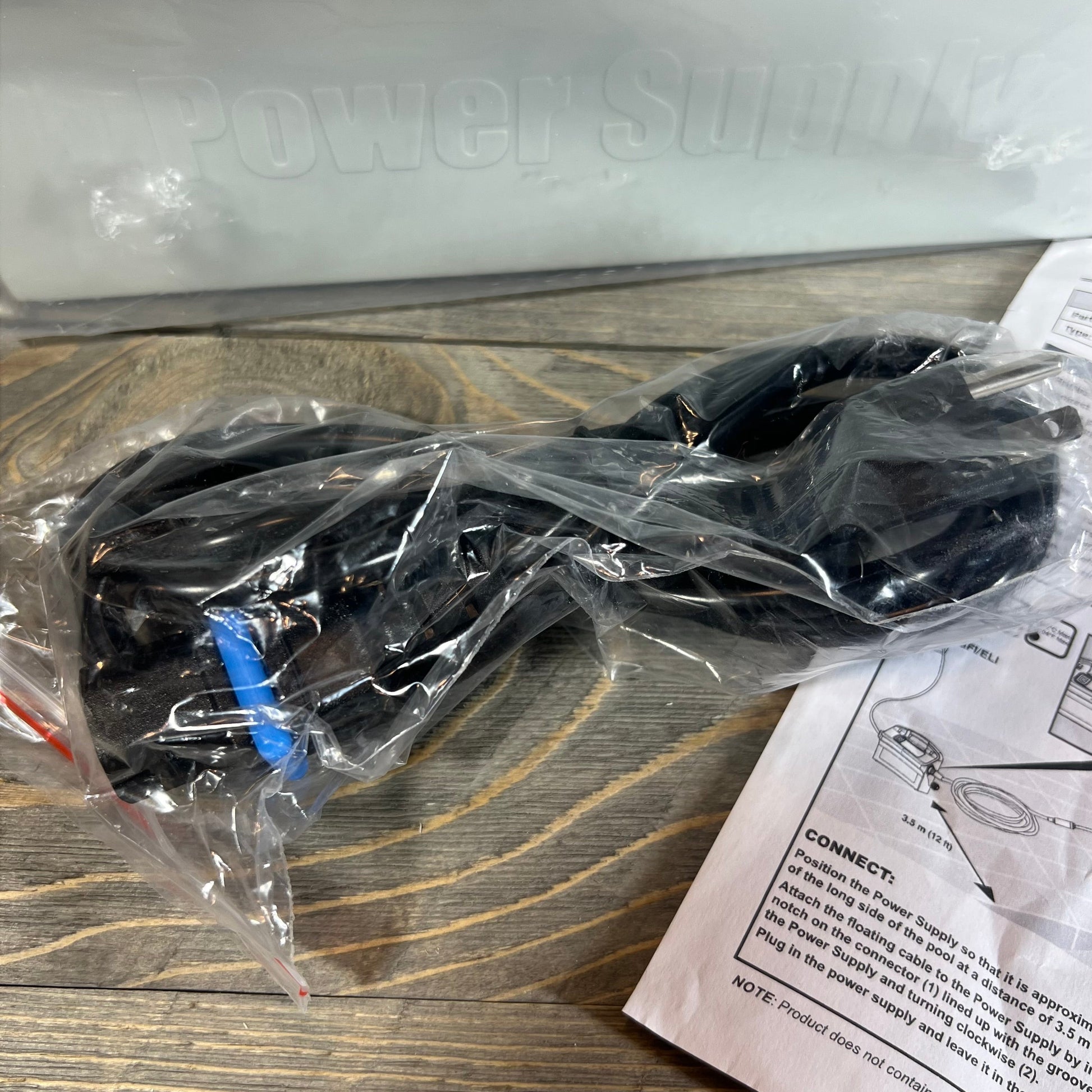 Power supply replacement cable for Dolphin Diagnostic models in packaging on a wooden surface with instructions nearby.